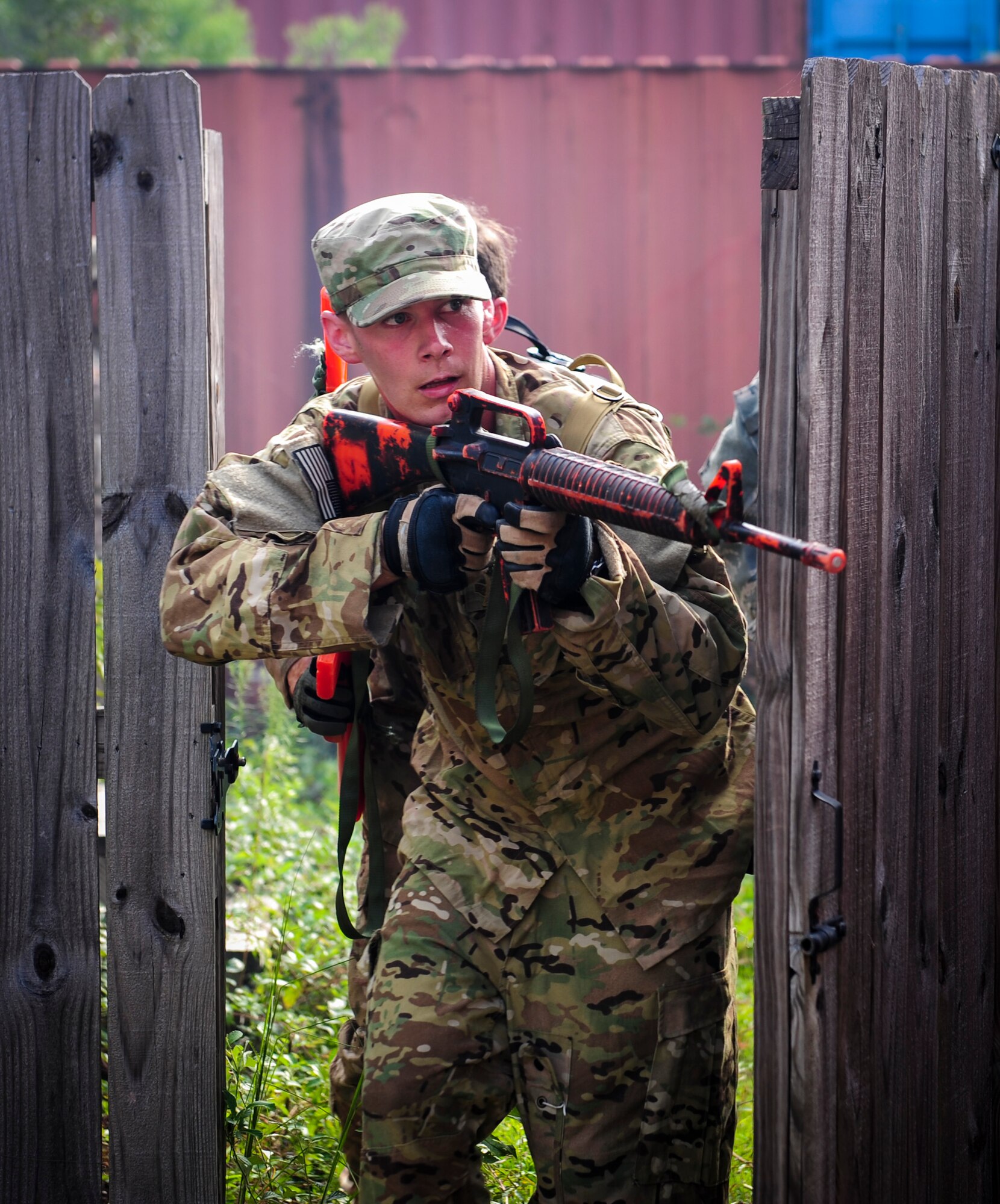 Staff Sgt. Joseph McMath, 4th Special Operations Squadron aerial gunner, peers around a fence during urban clearing training at Eglin Field Complex, Fla., Sept. 2, 2015. Aircrew members participate in combat survival training tri-annually to maintain proficiency on skills sets such as combative, evasion, navigation, signaling, radio use and discipline and contact procedures. (U.S. Air Force photo by Senior Airman Meagan Schutter)