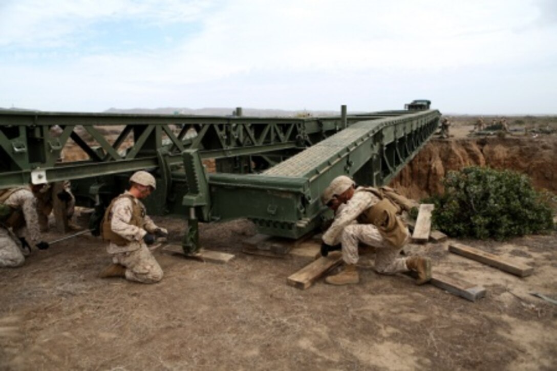 Engineers from Bridge Company, 7th Engineer Support Battalion, 1st Marine Logistics Group stabilize the end of a medium girder bridge aboard Camp Pendleton, Calif., Sept. 21, 2015. Marines from 7th ESB and 1st Combat Engineer Battalion are conducting various engineer training events alongside British Royal Engineers from the 54 Commando Squadron in coming weeks as part of annual large-scale exercise Black Alligator.