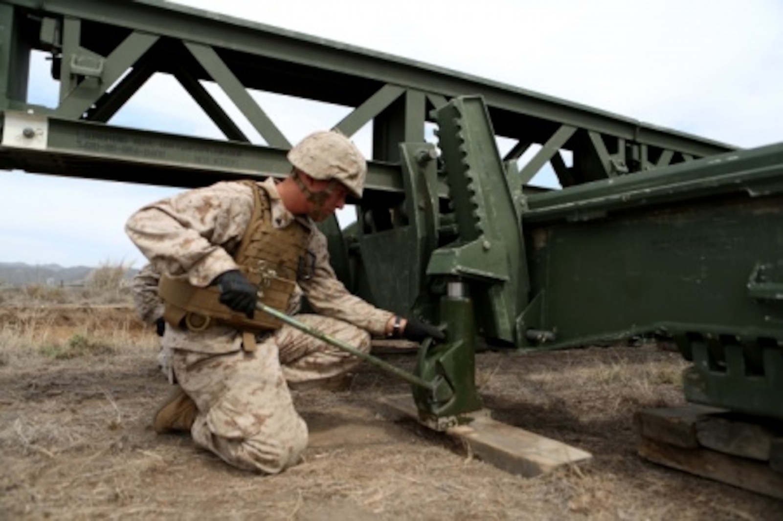 Cpl. James Stroeher, a combat engineer with Bridge Company, 7th Engineer Support Battalion, 1st Marine Logistics Group uses a 20-ton jack to lift the end of a medium girder bridge so other engineers can form a stabilizing platform for the massive bridge aboard Camp Pendleton, Calif., Sept. 21, 2015. Marines from 7th ESB and 1st Combat Engineer Battalion, 1st Marine Division are conducting various engineer training events alongside British Royal Engineers from the 54 Commando Squadron in coming weeks as part of annual large-scale exercise Black Alligator.