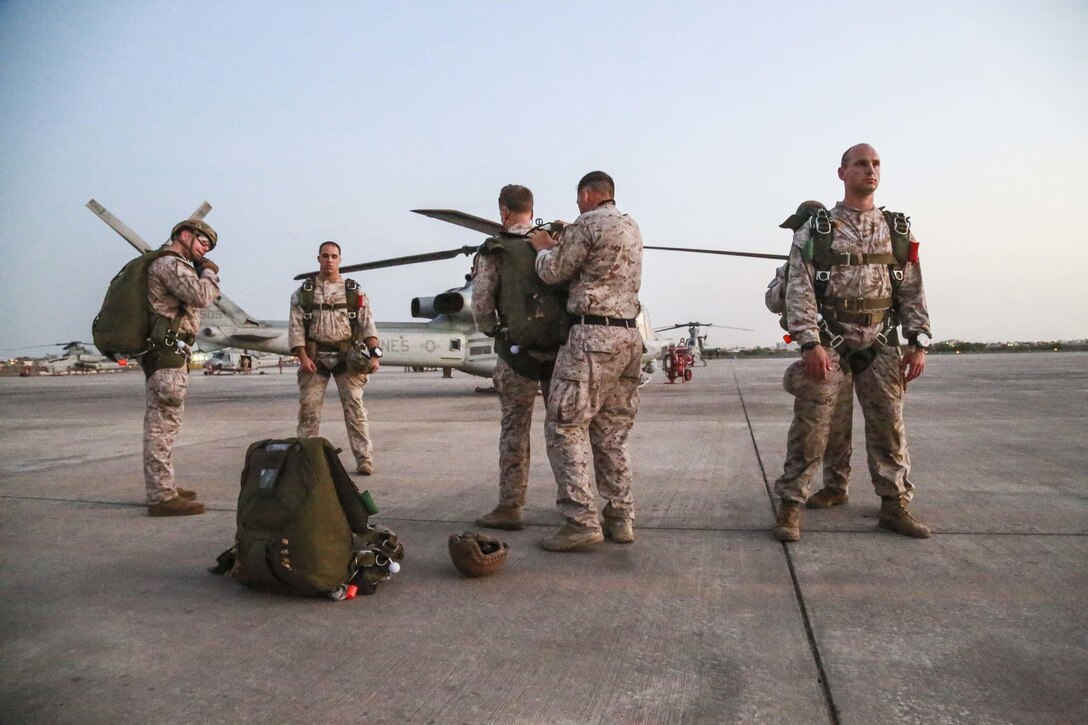 CAMP LEMONNIER, Djibouti (Sept. 16, 2015) U.S. Marines with the 15th Marine Expeditionary Unit’s Force Reconnaissance Detachment inspect each other’s parachutes prior to jumping out of a UH-1Y Venom from Marine Medium Tiltrotor Squadron 161 (Reinforced). Elements of the 15th MEU are conducting bilateral training with the 5th Overseas Combined Arms Regiment (RIAOM) and French paratroopers in Djibouti in order to improve interoperability between the MEU and the French military. (U.S. Marine Corps photo by Sgt. Steve H. Lopez/Released)
