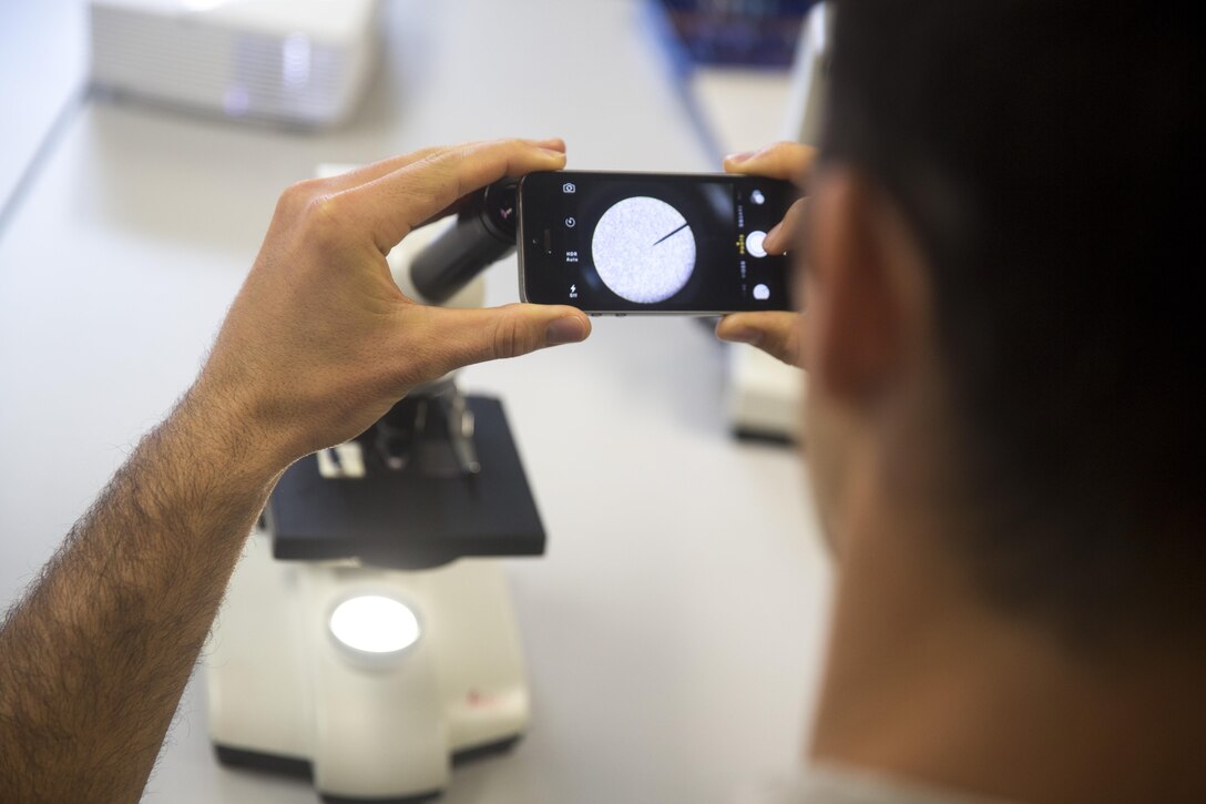 A Special Amphibious Reconnaissance Corpsman with U.S. Marine Corps Forces, Special Operations Command, uses takes photographs a blood sample through a microscope during the practical application portion of the Walter Reed Army Institute of Research’s Operational Clinical Infectious Diseases course held aboard Marine Corps Base Camp Lejeune, N.C., Sept. 10, 2015. Special Amphibious Reconnaissance Corpsmen and MARSOC medical practitioners took advantage of the course to better prepare for future deployments. While forward deployed, medical personnel are advised to take photos of anything they deem questionable, and send the files to an expert for further examination.