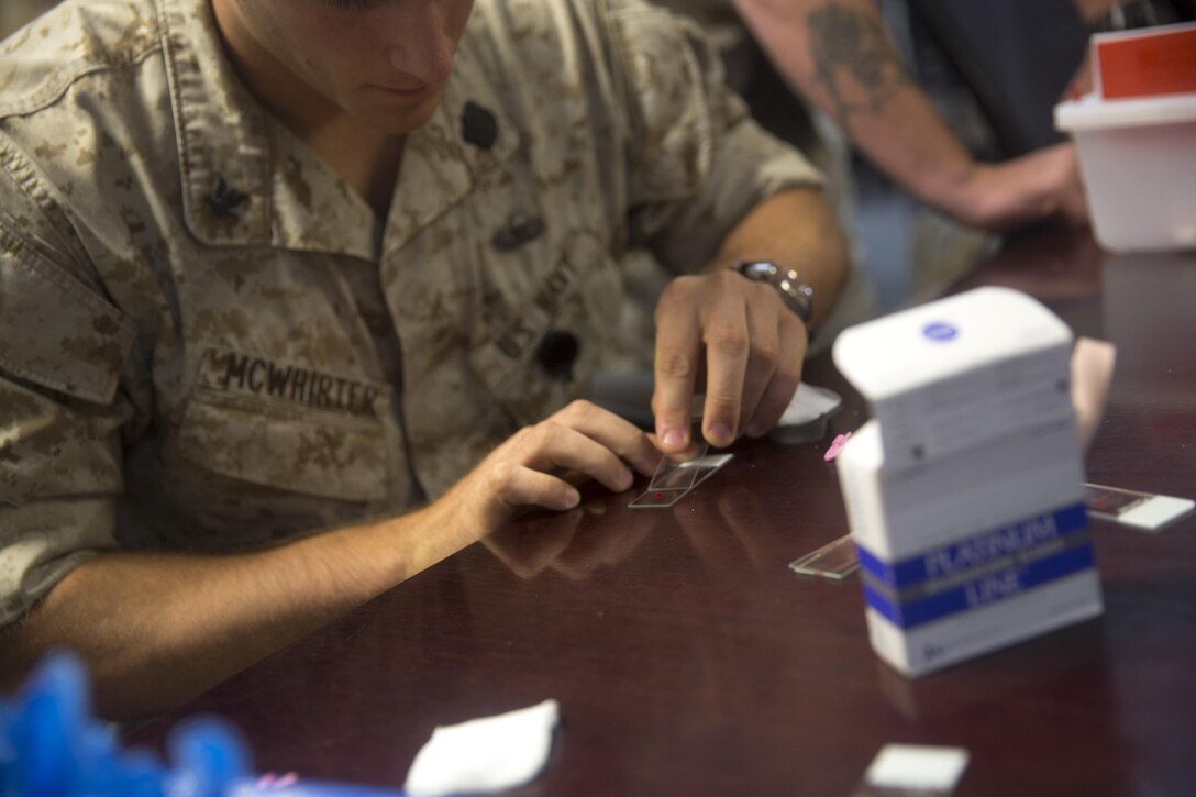 A Special Amphibious Reconnaissance Corpsman with U.S. Marine Corps Forces, Special Operations Command, feathers a sample of blood on microscope slides during the Walter Reed Army Institute of Research’s Operational Clinical Infectious Diseases course, aboard Marine Corps Base Camp Lejeune, N.C., Sept. 10, 2015. Special Amphibious Reconnaissance Corpsmen and MARSOC medical practitioners took advantage of the course to better prepare for future deployments.