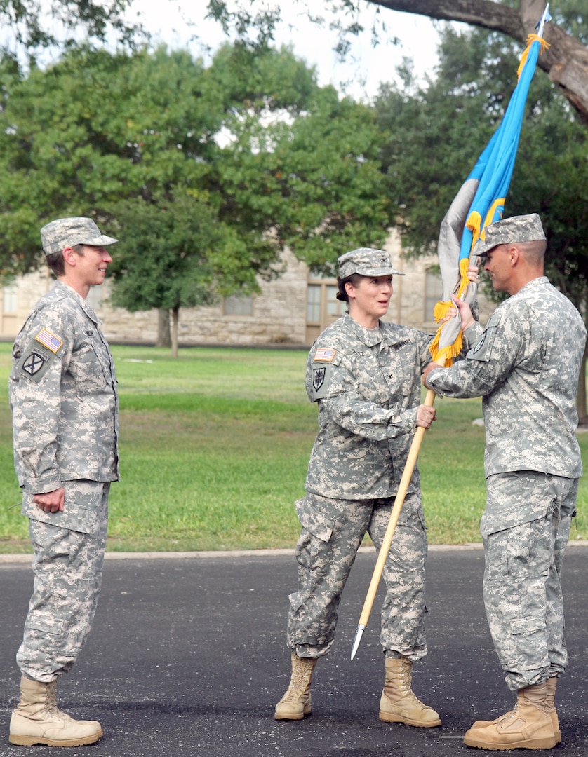 Col. Dustin Schultz (center), commander of the newly established 505th Military Intelligence Brigade (Theater), passes the unit colors to 505th MIB Command Sgt. Maj. Richard Hall (right) during a unit activation ceremony on Fort Sam Houston Friday. Presiding over the ceremony was Brig. Gen. Christie Nixon (left), commanding general of the U.S. Army Military Intelligence Readiness Command.