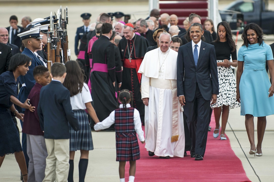 Pope Francis and President Barack Obama smile as they prepare to greet Catholic school children on Joint Base Andrews, Md., Sept. 22, 2015. The children gave Pope Francis flowers. U.S. Air Force photo by Airman 1st Class Philip Bryant