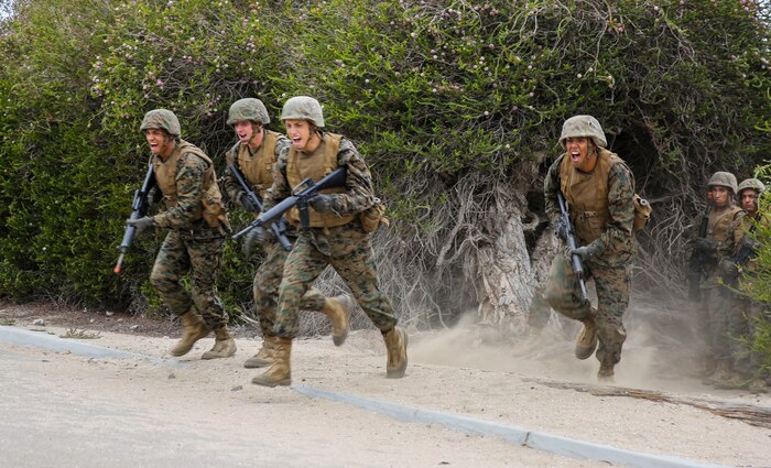Recruits of Fox Company, 2nd Recruit Training Battalion, run across the street in a fire team formation during the Bayonet Assault Course at Marine Corps Recruit Depot San Diego, Sept. 15. The recruits had run the course earlier in training, but this time they had to complete it in the rain. Today, all males recruited from west of the Mississippi are trained at MCRD San Diego. The depot is responsible for training more than 16,000 recruits annually. Fox Company is scheduled to graduate Oct. 9.