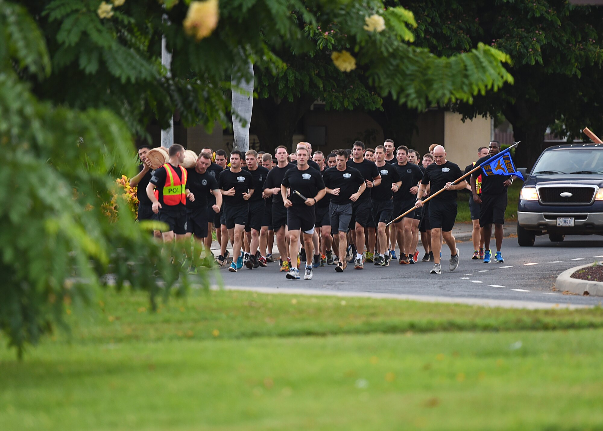 Airmen from the 25th Air Support Operations Squadron run in formation from Earhart track to Atterbury Circle at the conclusion of the 24 hour Prisoner of War and Missing In Action remembrance run on Joint Base Pearl Harbor-Hickam, Hawaii, Sept. 18, 2015. The 24-hour POW/MIA remembrance run was organized by the 25th Air Support Operations Squadron as a part of POW/MIA week and National POW/MIA Day. Every year the nation pauses on the third Friday of September to remember the sacrifices and service of prisoners of war. There are 83,344 Americans still unaccounted-for across the Defense Department. (U.S. Air Force photo by Tech. Sgt. Aaron Oelrich/Released)   