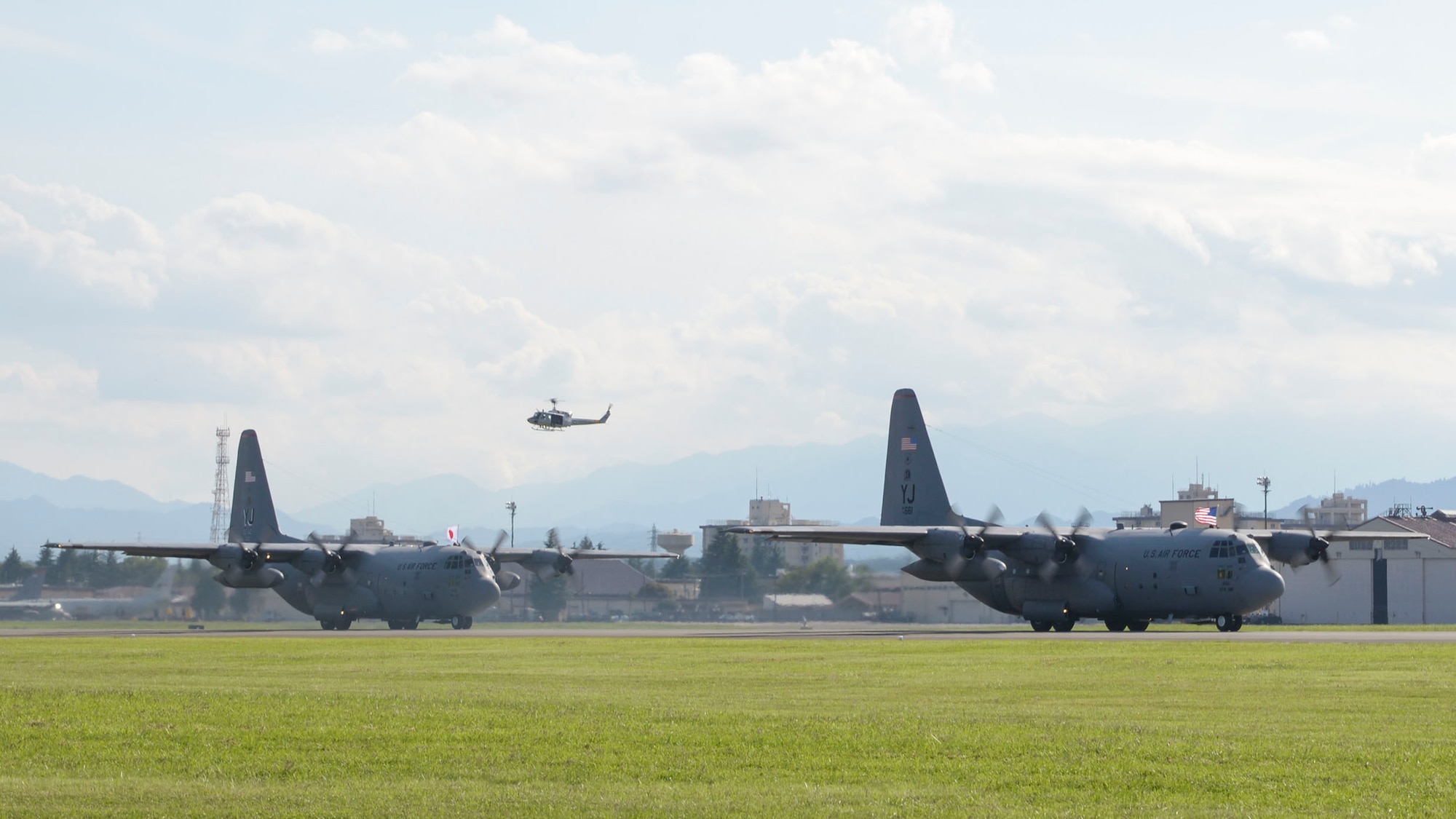 Aircrew with the 36th Airlift Squadron hold US and Japanese national flags outside C-130 Hercules during the 2015 Japanese-American Friendship Festival at Yokota Air Base, Japan, Sept. 20, 2015. More than 185,000 people attended the annual festival. (U.S. Air Force photo by Staff Sgt. Cody H. Ramirez/Released)