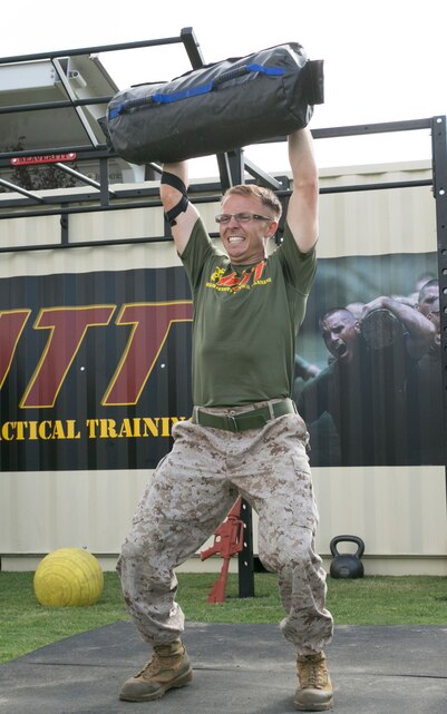 Cpl. Jonathan Fuller, team leader, Signals Intelligence Support Team, 1st Radio Battalion, based out of Camp Pendleton, Calif., lifts a 90 pound sand bag during the High Intensity Tactical Training Ultimate Tactical Championship at Del Valle Field, Sept. 15, 2015. This is the first HITT Ultimate Tactical Championship the Marine Corps has held. (Official Marine Corps photo by Lance Cpl. Thomas Mudd/Released)