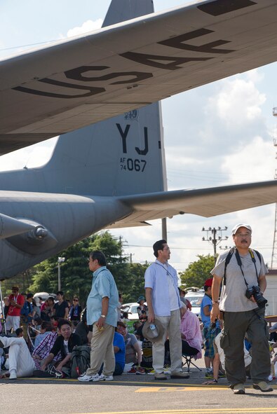 Attendees hide find shade under a C-130 Hercules during the 2015 Japanese-American Friendship Festival at Yokota Air Base, Japan, Sept. 20, 2015. More than 185,000 people attended the annual festival. (U.S. Air Force photo by Staff Sgt. Cody H. Ramirez/Released)