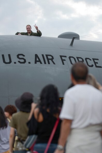 An aircrew member waves from a C-130 Hercules during the 2015 Japanese-American Friendship Festival at Yokota Air Base, Japan, Sept. 20, 2015. The annual festival is aimed at increasing bilateral relationships between US and Japanese communities and allows people to see US and Japanese military capabilities first-hand. (U.S. Air Force photo by Staff Sgt. Cody H. Ramirez/Released)