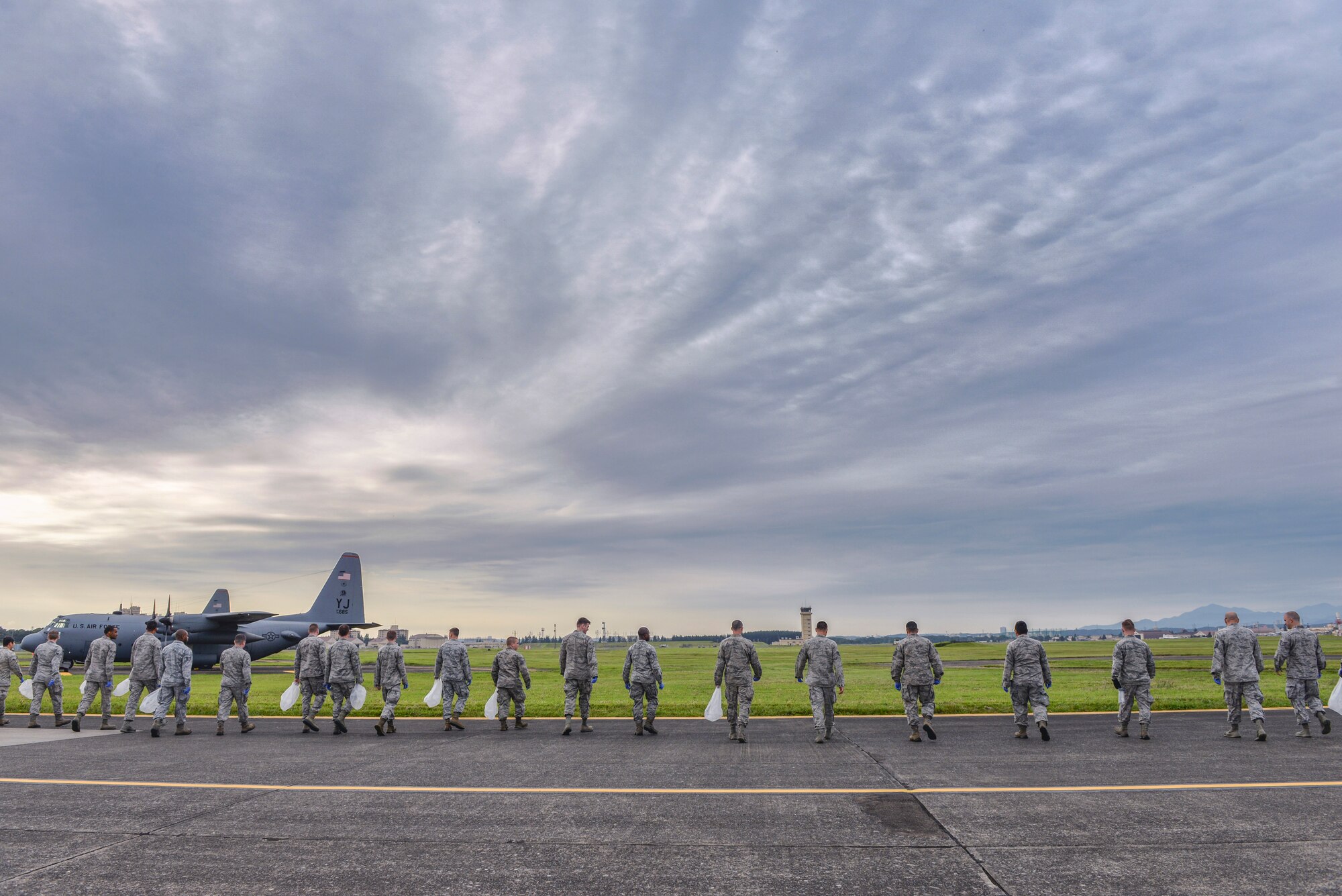 Airmen perform a foreign object debris walk Sept. 21, 2015, at Yokota Air Base, Japan. FOD creates safety hazards and can ultimately impact safe operations by damaging aircraft. The FOD walk helps to clear the flightline of trash and debris before it can cause damage. (U.S. Air Force photo by Airman 1st Class Delano Scott/Released)