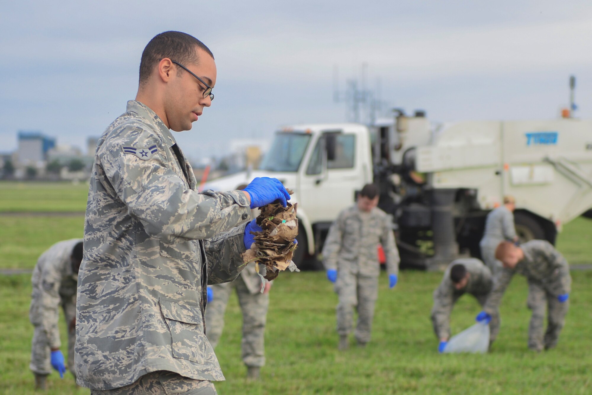 Airmen perform a foreign object debris walk Sept. 21, 2015, at Yokota Air Base, Japan. A FOD walk is a preventative measure that ensures debris is remove from the airfield before it causes damage to aircraft. (U.S. Air Force photo by Airman 1st Class Delano Scott/Released)
