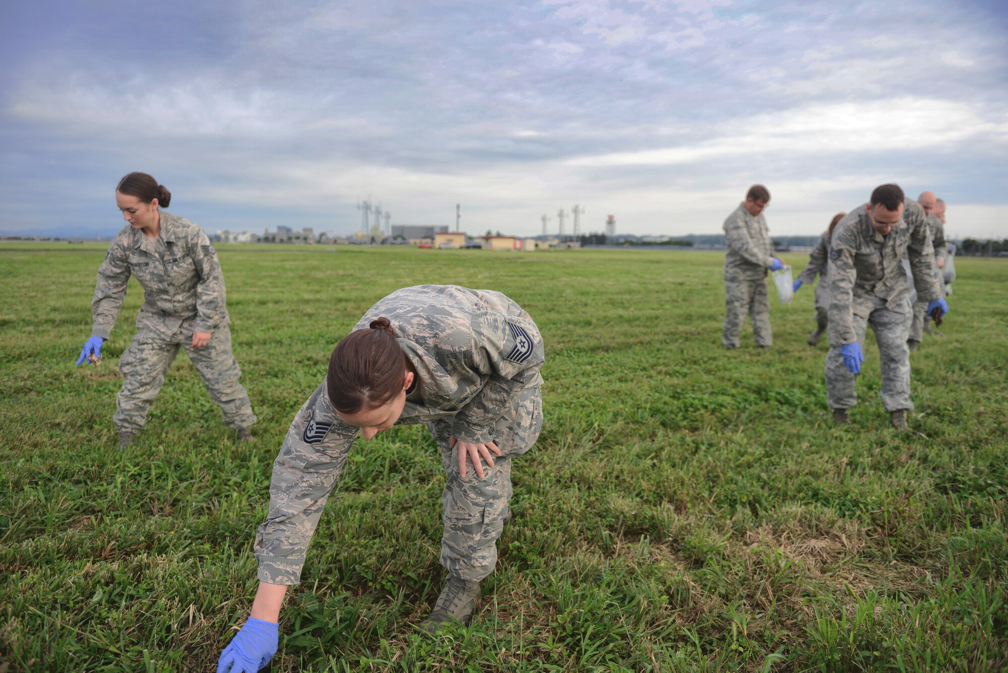 Airmen perform a foreign object debris walk Sept. 21, 2015, at Yokota Air Base, Japan. The entire 374th Airlift Wing came together the day after Yokota’s Friendship Festival to collect any potentially harmful objects from the flightline. (U.S. Air Force photo by Airman 1st Class Delano Scott/Released)
