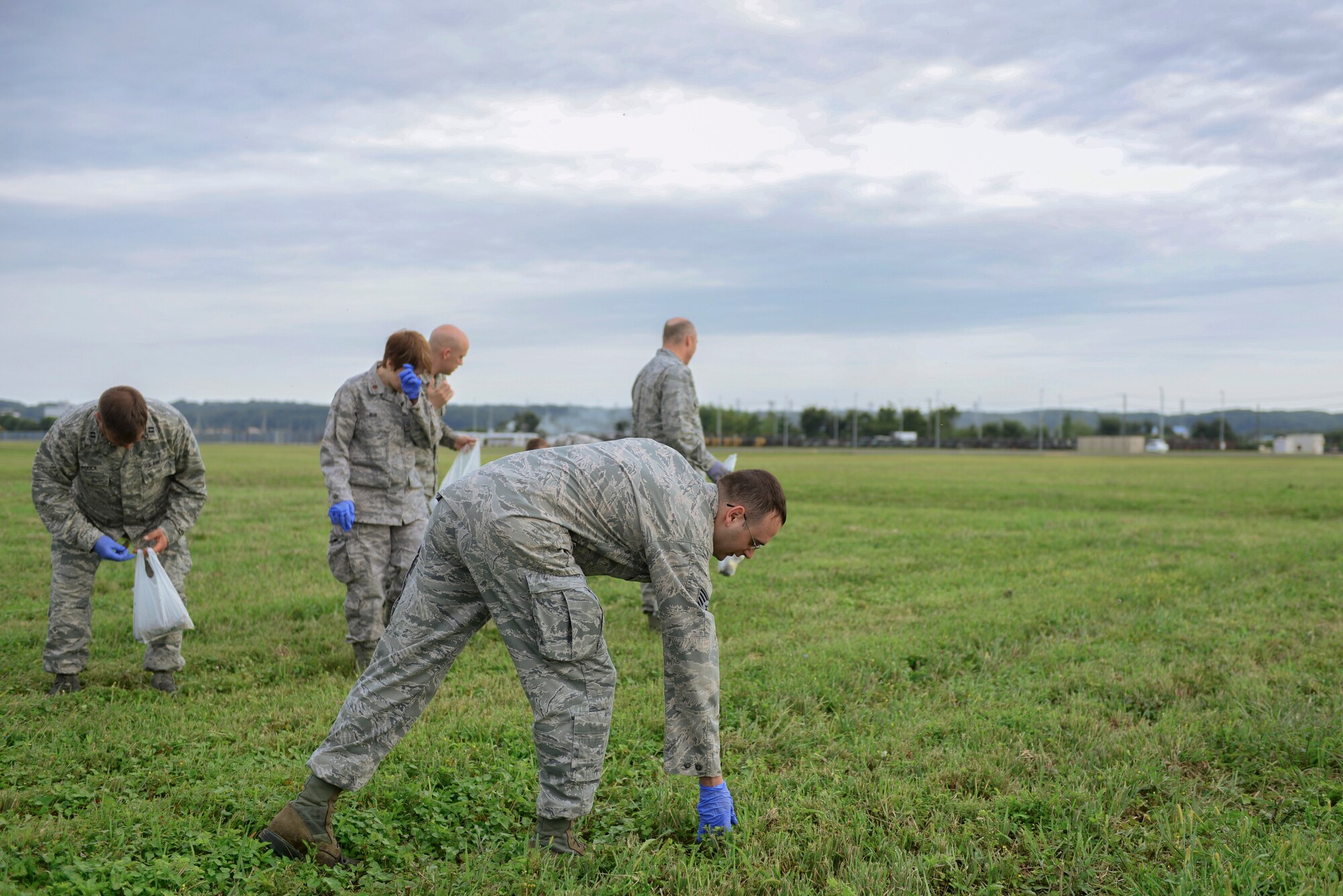 Airmen perform a foreign object debris walk Sept. 21, 2015, at Yokota Air Base, Japan. During a FOD walk, Airmen spread out and walk the airfield, picking up any loose objects hazardous to aircraft. (U.S. Air Force photo by Airman 1st Class Delano Scott/Released)