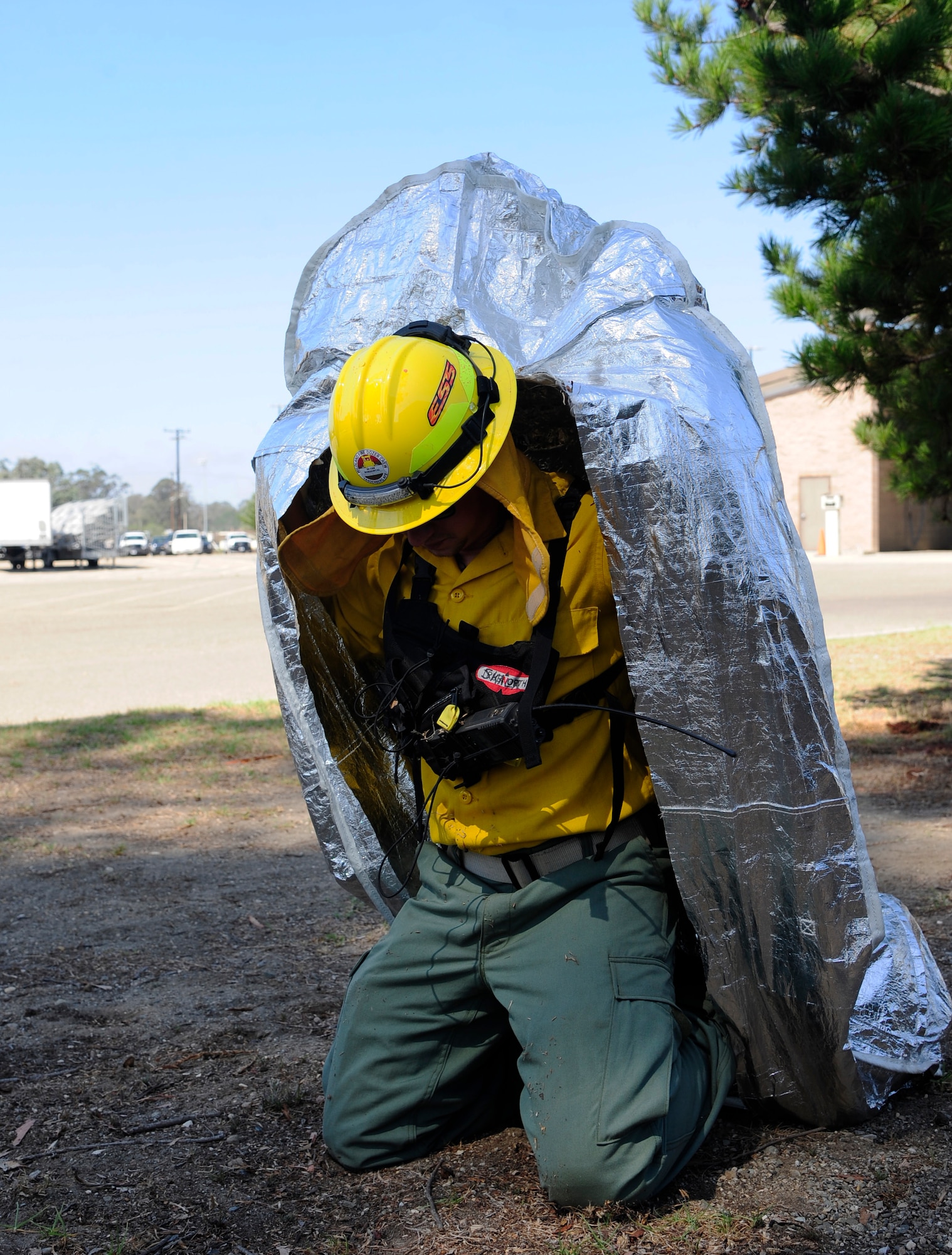 Senior Airman Ronald Skala, 30th Civil Engineer Squadron heavy equipment operator, demonstrates the use of a Fire Shelter, Sept. 21, 2015, Vandenberg Air Force Base, Calif. Constructed of aluminum foil, silica and fiberglass, a fire shelter is designed to protect the individual from smoke, heat and flames. (U.S. Air Force photo by Senior Airman Kyla Gifford/Released)