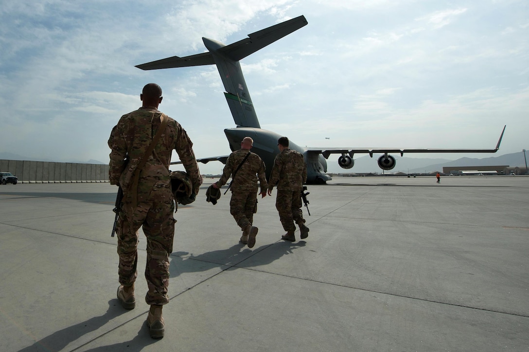 U.S. soldiers walk to an U.S. Air Force C-17 Globemaster III aircraft to offload mine-resistant, ambush-protected vehicles on Bagram Airfield, Afghanistan, Sept. 21, 2015. The soldiers are assigned to 1st Armored Division's Resolute Support Sustainment Brigade. U.S. Air Force photo by Tech. Sgt. Joseph Swafford