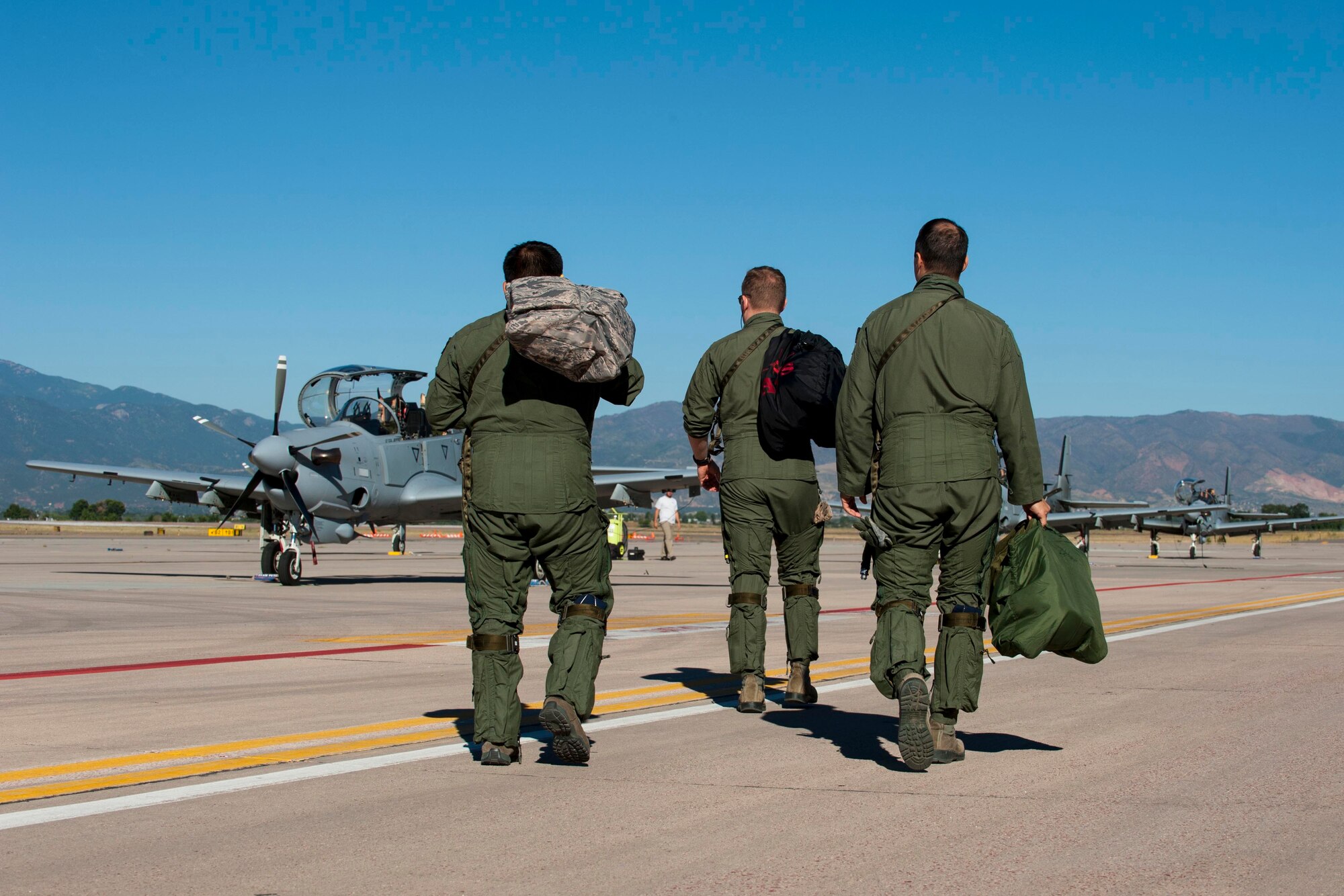 Two pilots from the 81st Fighter Squadron out of Moody Air Force Base, Georgia, and an Afghan pilot walk to several A-29B Super Tucanos to prepare for high-altitude training Sept. 16, 2015, at Peterson Air Force Base, Colorado. Four Afghan pilots have been training with the 81st FS on the aircraft since January in Georgia and came to Peterson to experience high-altitude and mountainous terrain. After completing their training in the U.S., both the American and Afghan pilots will go to Afghanistan to help establish fighter squadrons. The 81st FS is a component of the 14th Flying Training Wing, Columbus Air Force Base, Mississippi, under AETC. (U.S Air Force photo by Airman 1st Class Rose Gudex)