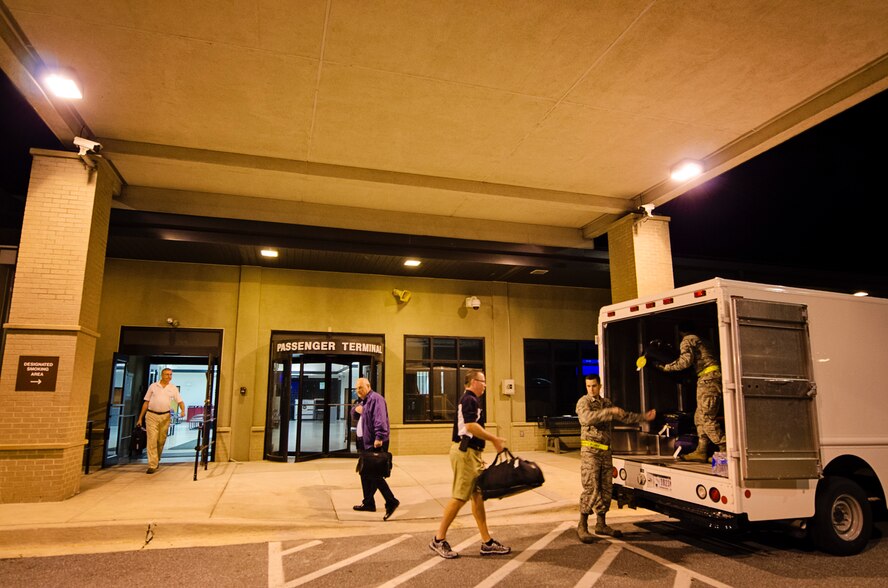 Civic leaders from Team Dover hand their luggage off to Airmen from the 436th Passenger Terminal, on Dover Air Force Base, Del., Sept. 16, 2015, prior to boarding a C-17 Globemaster III flight to Luke Air Force Base, Ariz., as part of Dover AFB's 2015 community relations tour. CRTs are designed to engage local leaders from the Dover community with unique missions from different military bases outside of the Air Mobility Command. (U.S. Air Force photo/Capt. Bernie Kale)