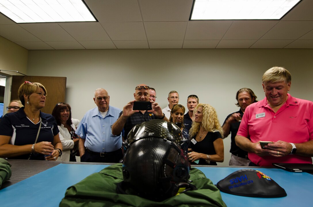 Team Dover civic leaders take photos of a helmet specially designed for an F-35 Lightning fighter jet, Sept. 16, 2015, Luke Air Force Base, Ariz., as part of Dover AFB's 2015 community relations tour. The F-35 helmet costs 400-thousand dollars for each one and is specifically designed for every pilot. (U.S. Air Force photo by Capt. Bernie Kale)