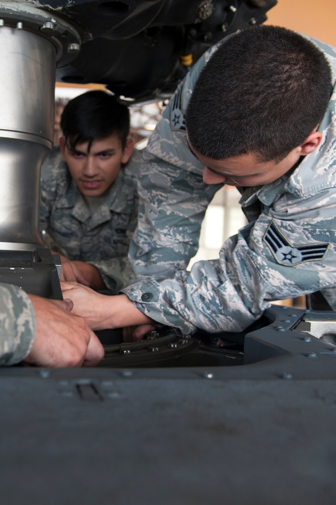 U.S. Air Force Senior Airmen Nico Rodriguez, (right), and Dylan Shephard, 41st Helicopter Maintenance Unit crew chiefs, loosen the lower pressure plate on an HH-60G Pave Hawk Sept. 22, 2015, at Moody Air Force Base, Ga. The 41st HMU Airmen replaced the helicopter’s shaft extension after it was dented. The helicopters receive this type of maintenance every 6 months. (U.S. Air Force photo by Airman 1st Class Kathleen D. Bryant/Released)
