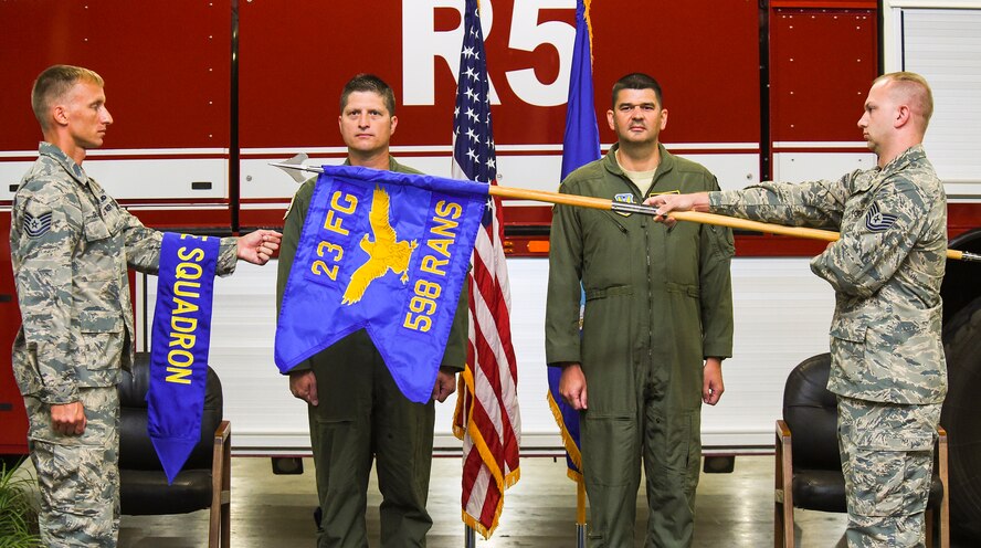 Airmen assigned to the 598th Range Squadron reveal the newly-activated 598th RANS’ guideon flag during the activation and assumption of command ceremony Sept. 22, 2015, at Avon Park Air Force Range, Fla. The squadron operates the range and a deployed unit complex while providing unique training capabilities for military air and ground training. (U.S. Air Force photo by Senior Airman Ceaira Tinsley/Released)