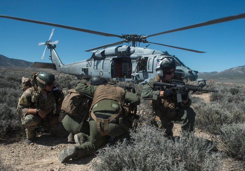 U.S. Air Force Senior Airman Dane Dougherty, 335 Training Group Survival, Evasion, Resistance and Escape specialist and Capt. Jack Green, 480 Fighter Squadron F-16 pilot run to a Sikorsky HH-60 Pave Hawk at the Nevada Test and Training Range, Nevada July 30, 2015. During Red Flag 15-3 the Pave Hawk was used to rescue a simulated downed pilot. (U.S. Air Force photo by Brittany A. Chase)