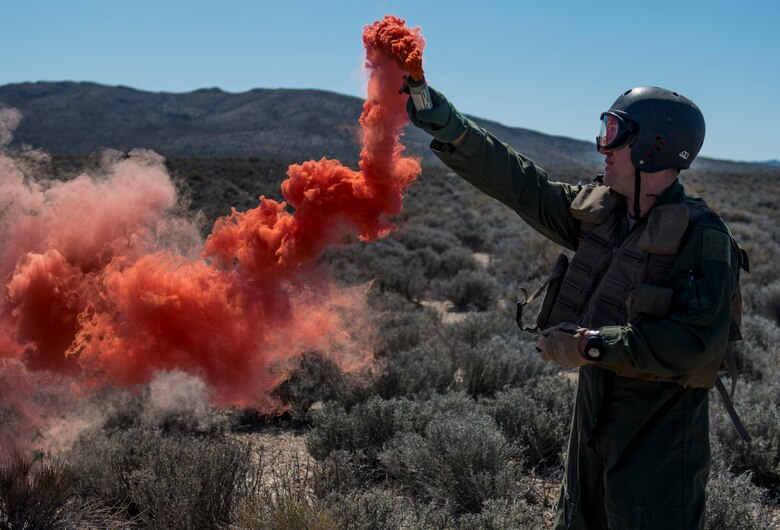 U.S. Air Force Capt. Jack Green, 480 Fighter Squadron F-16 pilot, signals aircraft using a flare Jul 30, 2015 at the Nevada Test and Training Range, Nevada. Green, who was simulating a downed pilot, was evaluated and trained by a SERE specialist during Red Flag 15-3. (U.S. Air Force Photo by Senior Airman Brittany A. Chase)