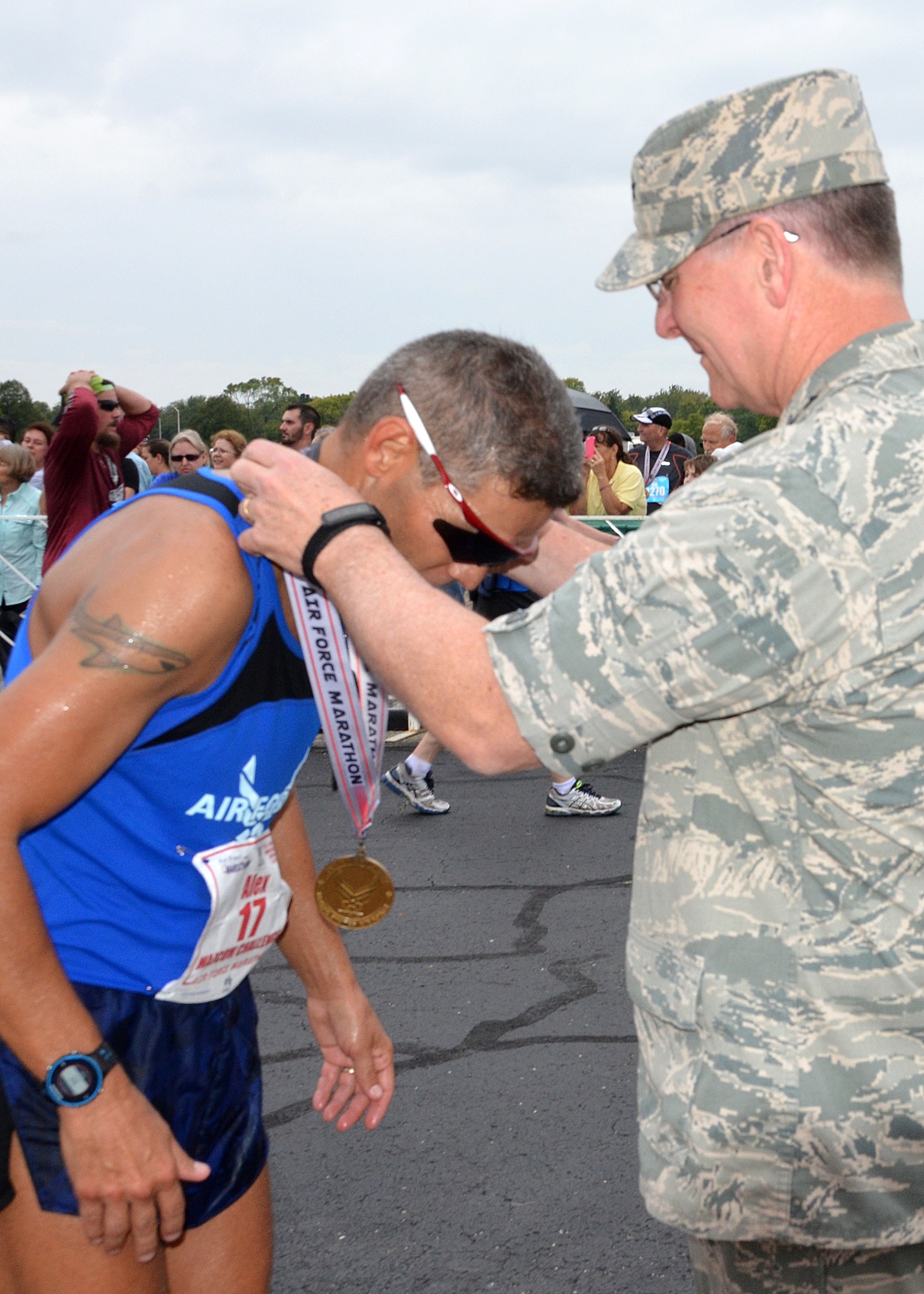 WRIGHT-PATTERSON AIR FORCE BASE, Ohio – Lt. Gen. James F. Jackson, the commander of the AFRC, awards a medal to Chief Master Sgt. Alex C. Escarcega, 310th Operations Group, Group Superintendent, after he crossed the finish line in the 19th Annual Air Force Marathon held Sept. 19, 2015. Escarcega was a member of the Air Force Reserve Command MAJCOM Challenge Team. The team consisted of traditional reservists, air reserve technicians, individual mobilization augmentees and Air Guard Reserve members. The MAJCOM challenge included six Airmen participating in the half marathon and four in the full marathon. (U.S. Air Force photo /Lt. Col. Cynthia Harris)