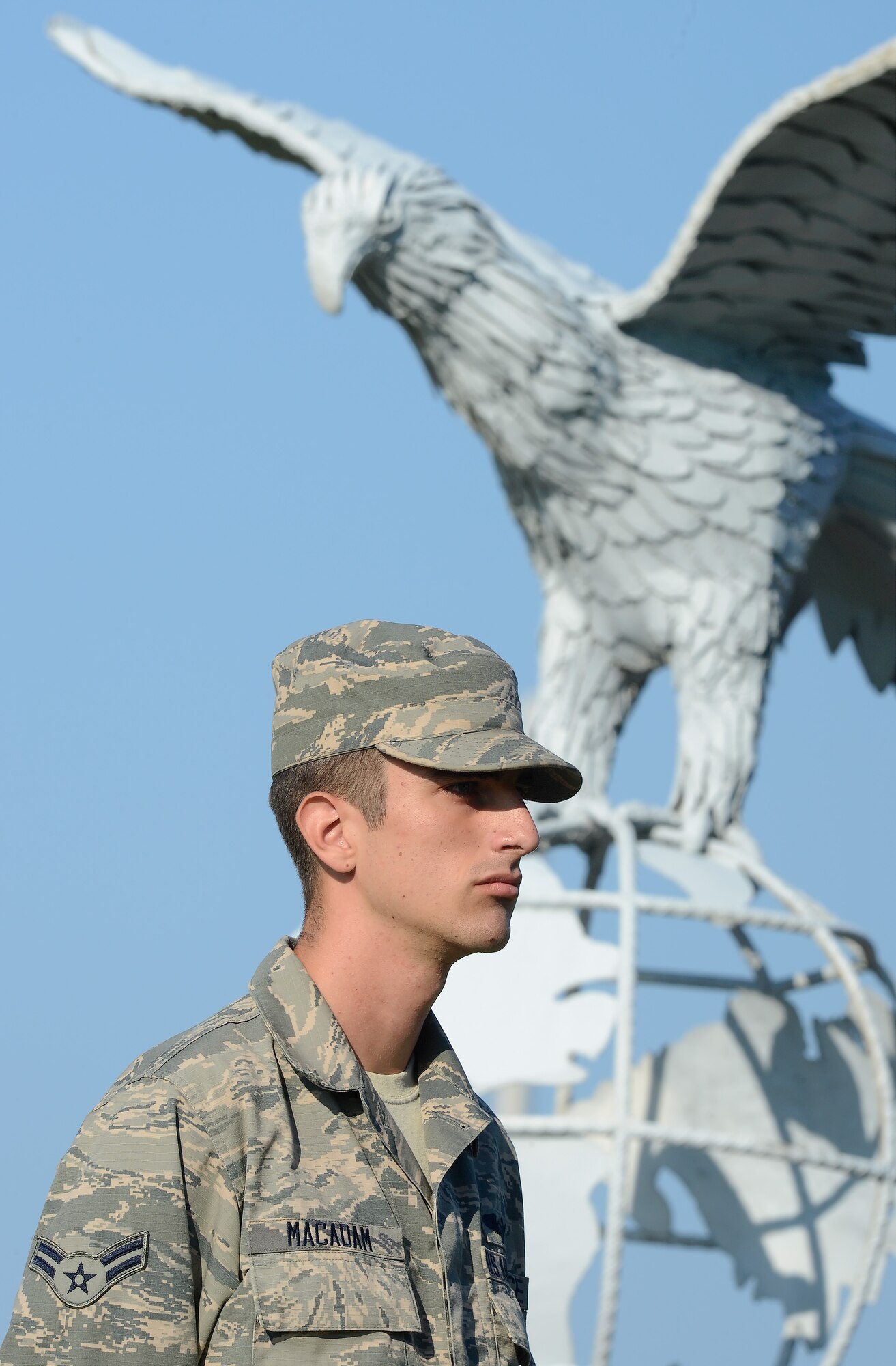 Airman 1st Class Ryan Macadam, 9th Airlift Squadron C-5M Super Galaxy loadmaster, stands stoicly under the watchful eye of Dover Air Force Base's iron eagle during the POW/MIA Rememberance Day on Sept. 18, 2015, on Dover AFB, Del. Team Dover conducted a run, vigil at the base flagpole a formal retreat ceremony. (U.S. Air Force photo/Greg L. Davis) 