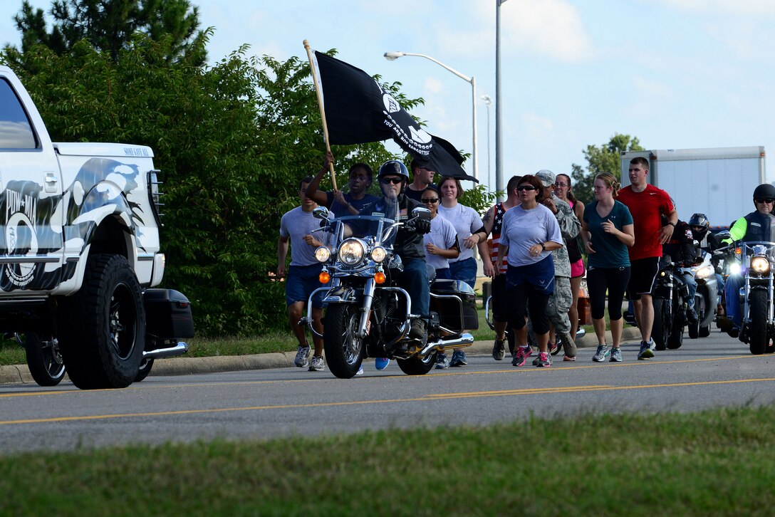 Participants run the final leg of the Joint Base Langley-Eustis, Va., 24-hour Prisoner of War/Missing in Action vigil at Langley Air Force Base, Va., Sept. 18, 2015. This year marked the 6th annual JBLE POW/MIA Recognition Day run/walk to remember U.S. Service members captured in time of war, who paid the ultimate sacrifice and those still unaccounted for. (U.S. Air Force photo by Senior Airman Kimberly Nagle/Released)