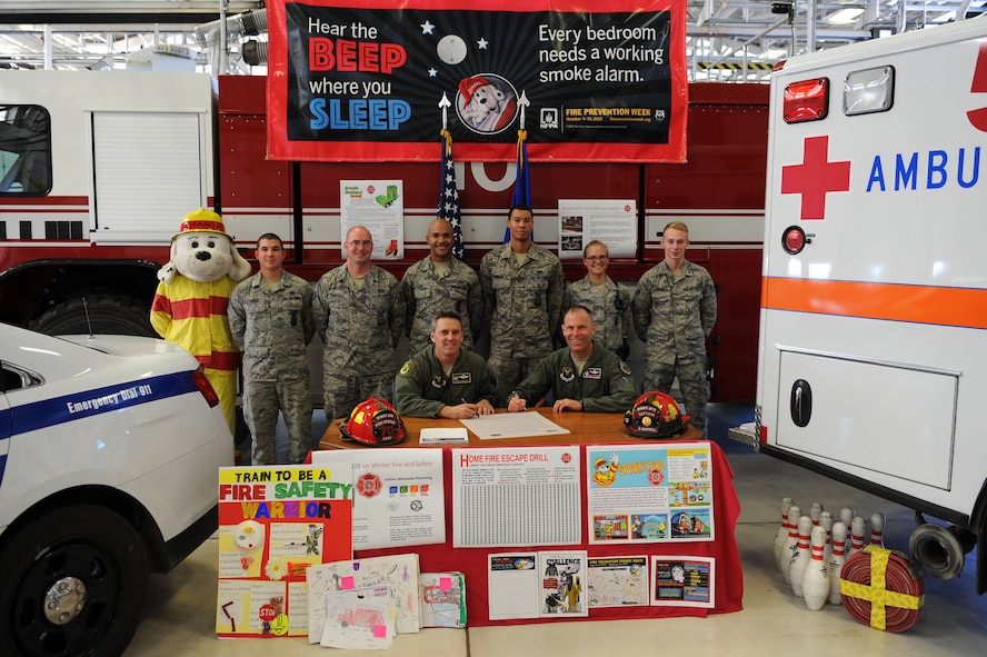 Col. Jason Armagost, 5th Bomb Wing commander and Col. Michael Lutton, 91st Missile Wing commander, sign a proclamation at Minot Air Force Base, N.D., Sept. 21, 2015. The proclamation represents the cooperation of all members of Minot AFB, both the 5th BW and 91st MW, to work toward continuing great fire prevention for the community. (U.S. Air Force photo/Senior Airman Kristoffer Kaubisch)