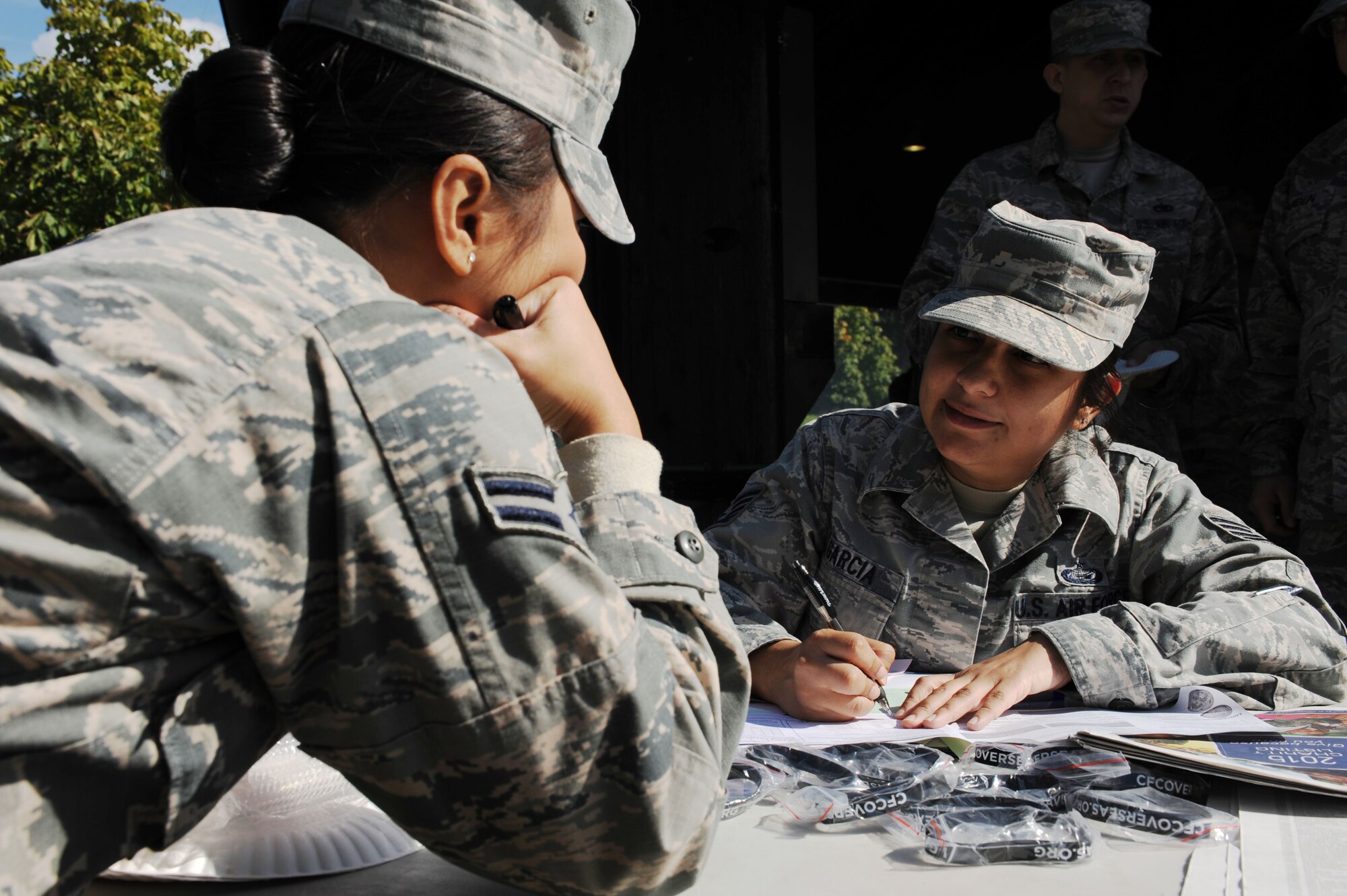 U.S. Air Force Airman 1st Class Marife Schultz, a 52nd Force Support Squadron force management technician, left, asks U.S. Air Force Tech. Sgt. Renata Garcia, 52nd FSS NCOIC of customer services and Combined Federal Campaign squadron representative, questions during the CFC-Overseas kickoff at the base pavilion on Spangdahlem Air Base, Germany, Sept. 21, 2015.  Participating community members were allowed to donate to a maximum of five charity organizations during the kickoff. The campaign’s mission is to promote and support philanthropy through a program that is employee-focused, cost-efficient and effective in providing all federal employees the opportunity to improve the quality of life for all. (U.S. Air Force photo by Airman 1st Class Timothy Kim/Released)