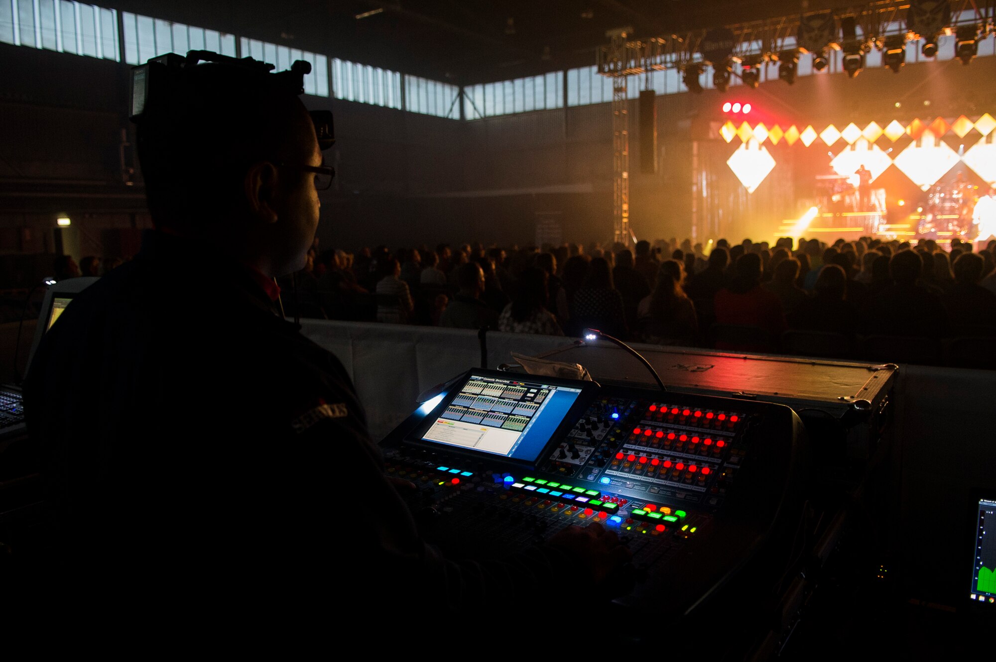 U.S. Air Force Airman 1st Class Jose Garcia, a Tops in Blue member, controls audio levels during a performance in Hangar 1 at Spangdahlem Air Base, Germany, Sept. 22, 2015. The group is responsible for transporting, loading, unloading and setting up more than 65,000 pounds of staging, lighting, audio, video and special effects equipment required for each performance. Garcia is a member of the 436th Force Support Squadron out of Dover Air Force Base, Del. (U.S. Air Force photo by Airman 1st Class Luke Kitterman/Released) 