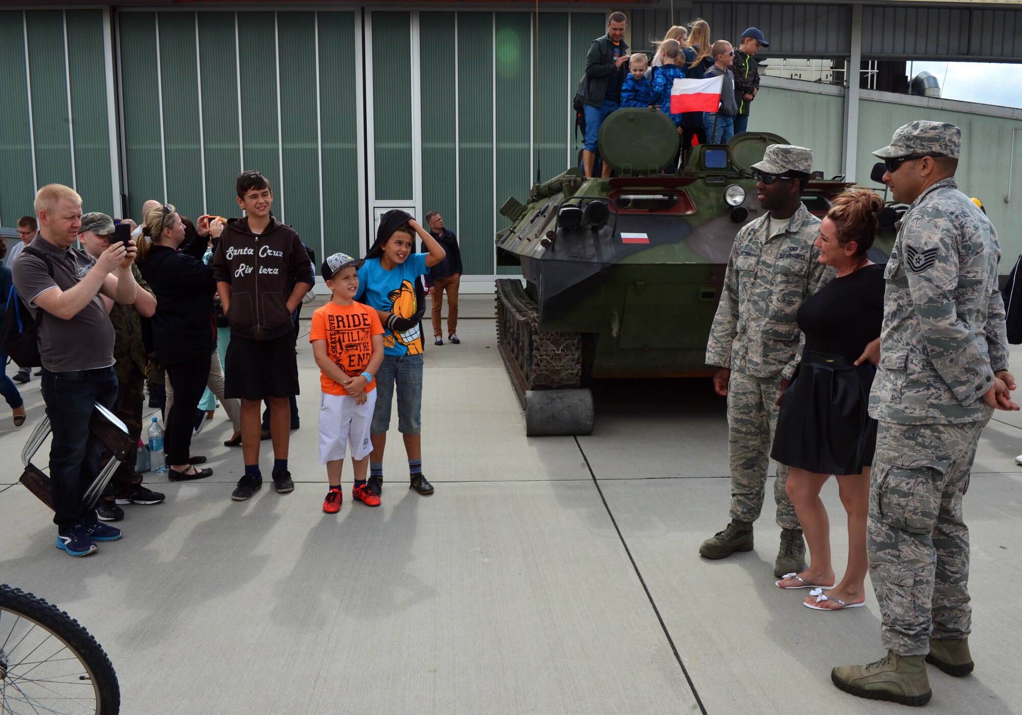 U.S. Air Force A1C Rydelle Nelson, data systems technician for the 606th Air Control Squadron, and Tech. Sgt. Samuel Rivera, air surveillance technician for the 606th ACS, pose for a picture with a Polish civilian during the Feast of the 31st Tactical Air Base Poznań-Krzesiny at Krzesiny Air Base, Poland Sept. 5, 2015. Approximately 10,000 people attended the day-long celebration. (U.S. Air Force photo by 2nd Lt. Meredith Mulvihill/Released)