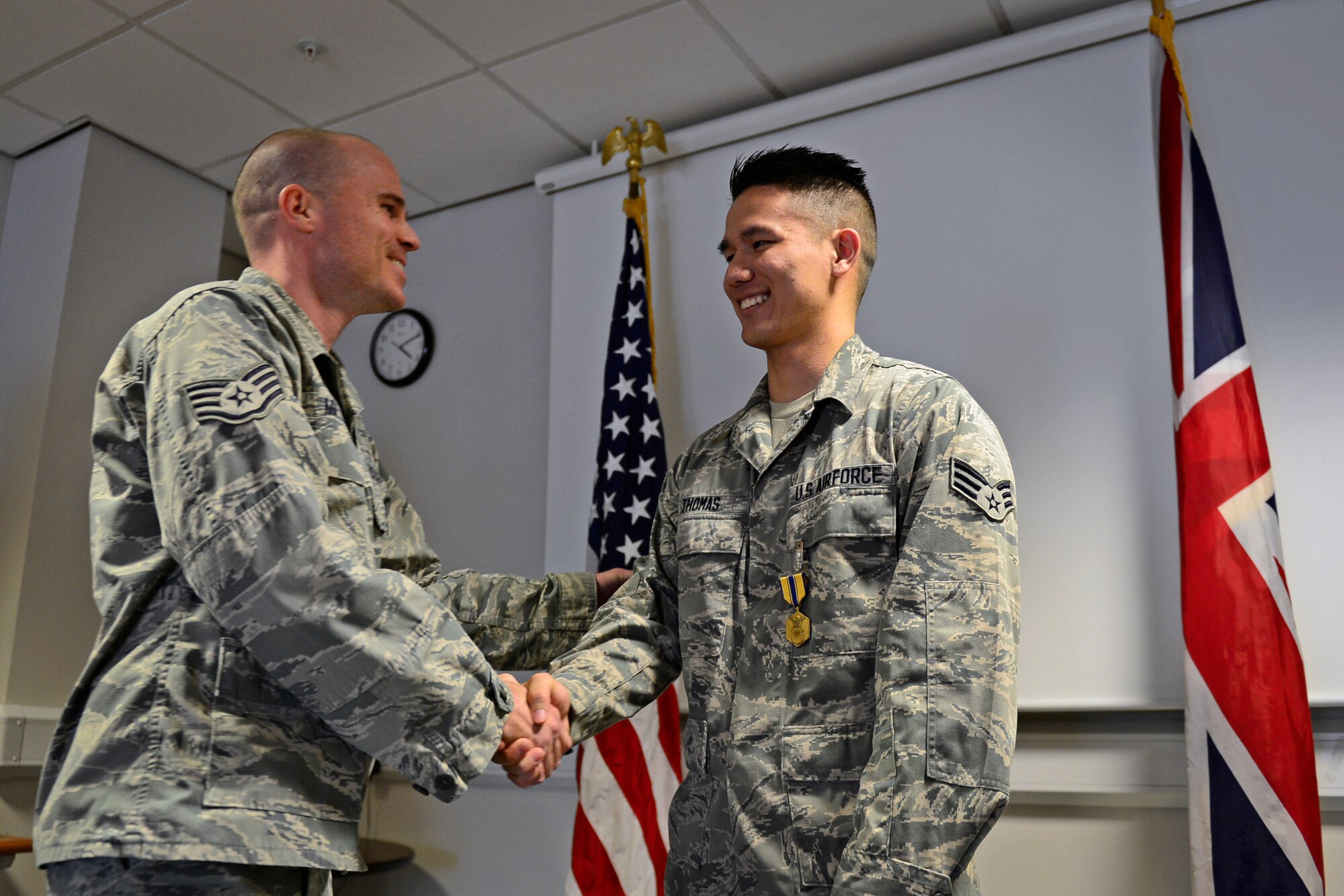 Airmen from the 48th Contracting Squadron congratulate Senior Airman Aaron Thomas, 48th CONS contracting specialist, after he was awarded the Air Force Commendation Medal at Royal Air Force Lakenheath, England, Sept. 22, 2015. He received the medal for his act of courage when responding to the cries of a gunshot victim and helping to stabilize him before the paramedics arrived on scene. (U.S. Air Force photo by Airman 1st Class Erin R. Babis/Released)