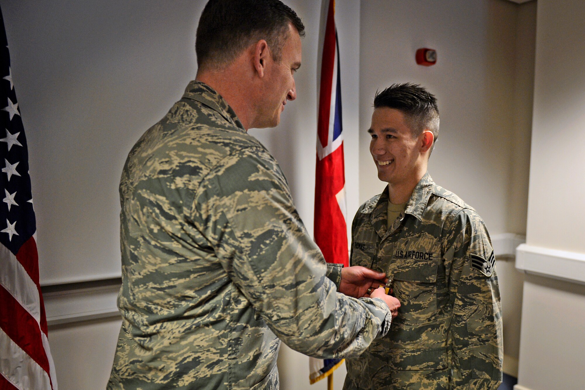 Col. Robert Novotny, 48th Fighter Wing commander, presents the Air Force Commendation Medal to Senior Airman Aaron Thomas, 48th Contracting Squadron contracting specialist, at Royal Air Force Lakenheath, England, Sept. 23. Thomas courageously helped save a gunshot victim in Bury St. Edmunds, Aug. 4, 2015. (U.S. Air Force photo by Airman 1st Class Erin R. Babis/Released)