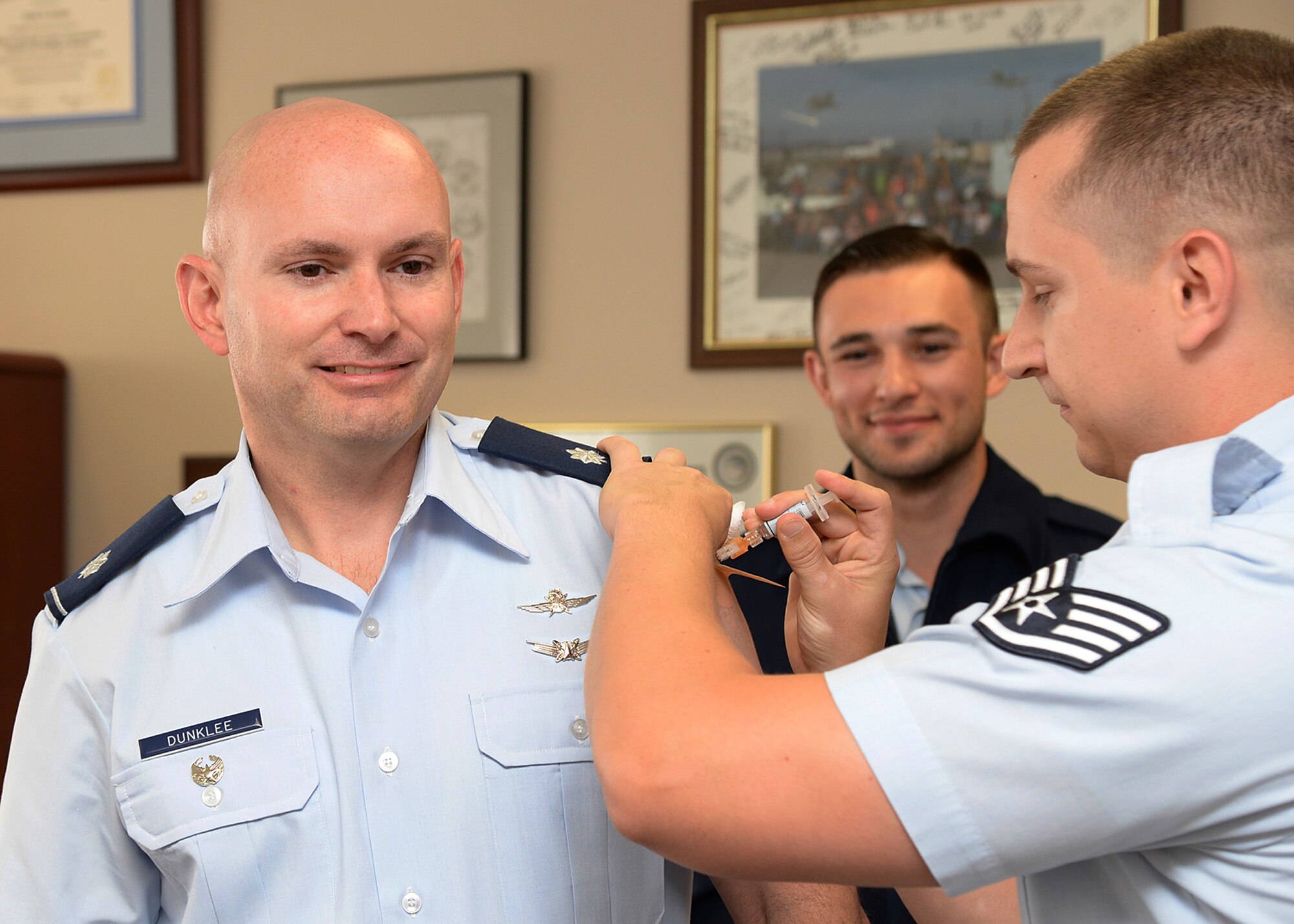 Lt. Col David Dunklee, 66th Air Base Group deputy commander, receives a flu shot from Staff Sgt. Sean Germain, Immunization NCO in charge, on base Sept. 21, while Airman 1st Class Jordan Phillips looks on. The clinic has received a limited supply of vaccinations only offered to deployers, first responders and specific personnel assigned to geographically separated units at this time. Public Health will notify the community when more shipments are received. (U.S. Air Force photo by Linda LaBonte Britt)
