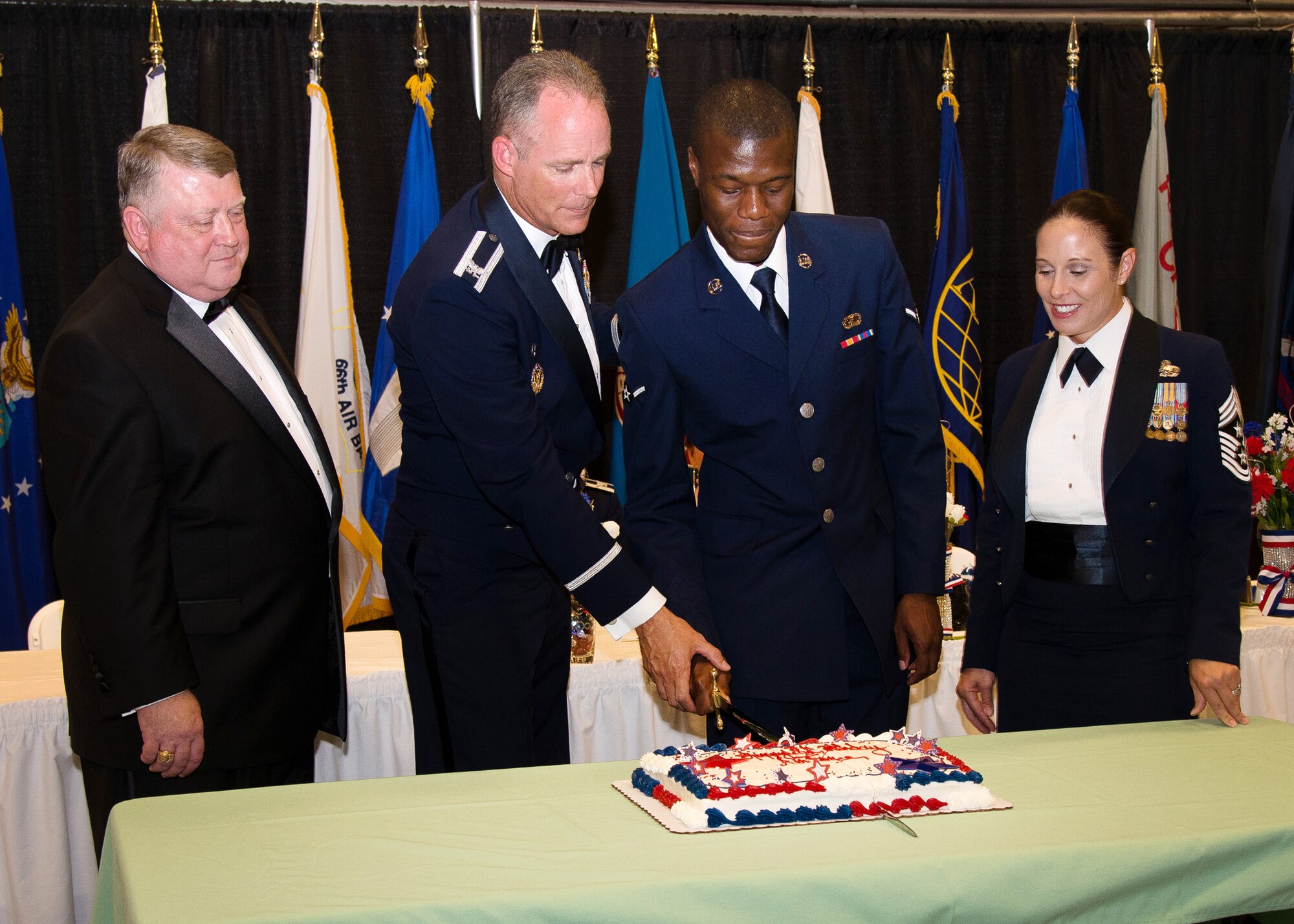 Col. Michael A. Vogel, 66th Air Base Group commander, and Airman Marcel Parker, 66th Comptroller Squadron customer service technician, cut a birthday cake during Hanscom's 68th United States Air Force Birthday Ball Sept. 18, while Jeffrey R. Mayo, the deputy assistant secretary of the Air Force for Force Management Integration, and Hanscom Command Chief Master Sgt. Patricia Hickey look on. The cake is traditionally cut by the highest ranking or presiding official and the youngest service member in attendance. (U.S. Air Force photo by Mark Herlihy)