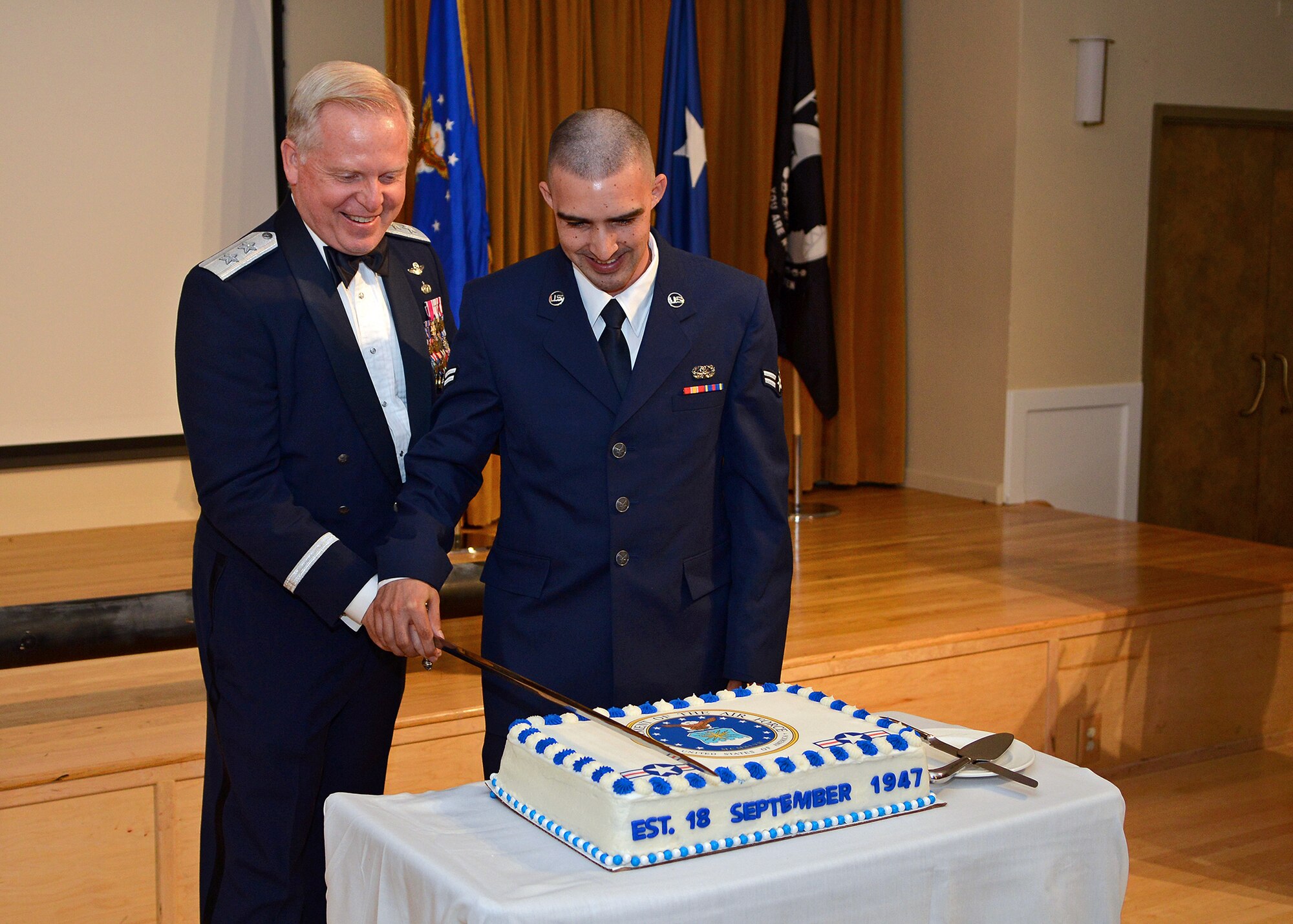 As keeping with tradition, the highest ranking officer, Maj. Gen. David Harris, Air Force Test Center commander, cuts the Air Force birthday cake with Airman 1st. Class Darrell Peters, 412th Communications Squadron, who is the youngest Airmen attending the Air Force birthday celebration at Club Muroc Sept. 18. (U.S. Air Force photo by Jet Fabara)
