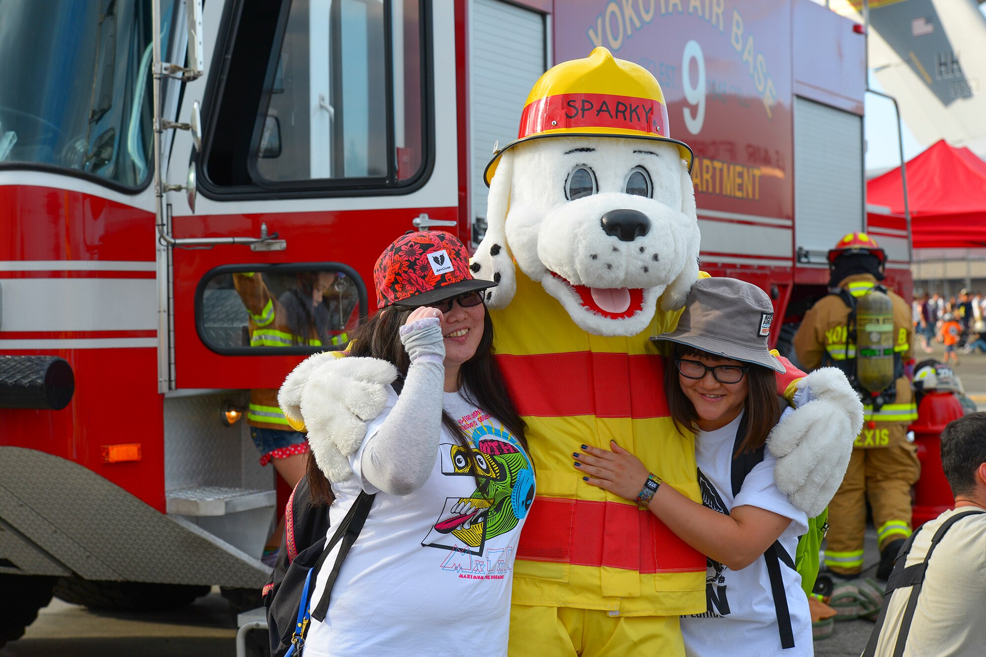 The 374th Civil Engineer Squadron fire department mascot poses for a picture with visitors during the Japanese-American friendship festival at Yokota Air Base, Japan, Sept. 20, 2015. Firemen, mascots, aircrew, parachutists and more strengthened bilateral relations by interacting with people at the festival. (U.S. Air Force photo by Airman 1st Class Elizabeth Baker/Released)