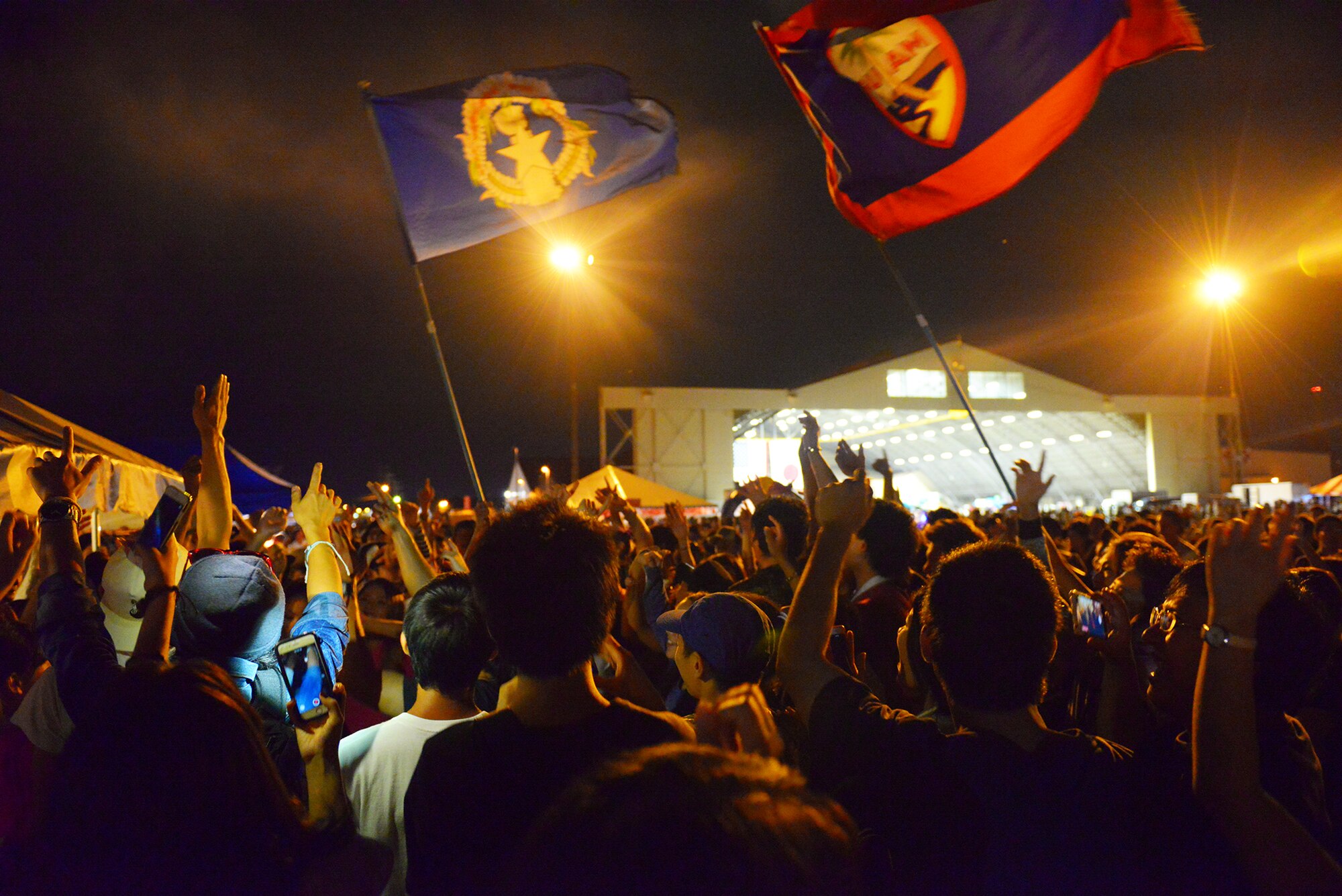 Festivalgoers jump and dance to pop music during the Japanese-American Friendship Festival at Yokota Air Base, Japan, Sept. 20, 2015. After the static aircraft display closed at 6:00 p.m., crowds moved to the other half of the flight line to eat, dance and enjoy the festival until the event closed with a fireworks display. (U.S. Air Force photo by Airman 1st Class Elizabeth Baker/Released)