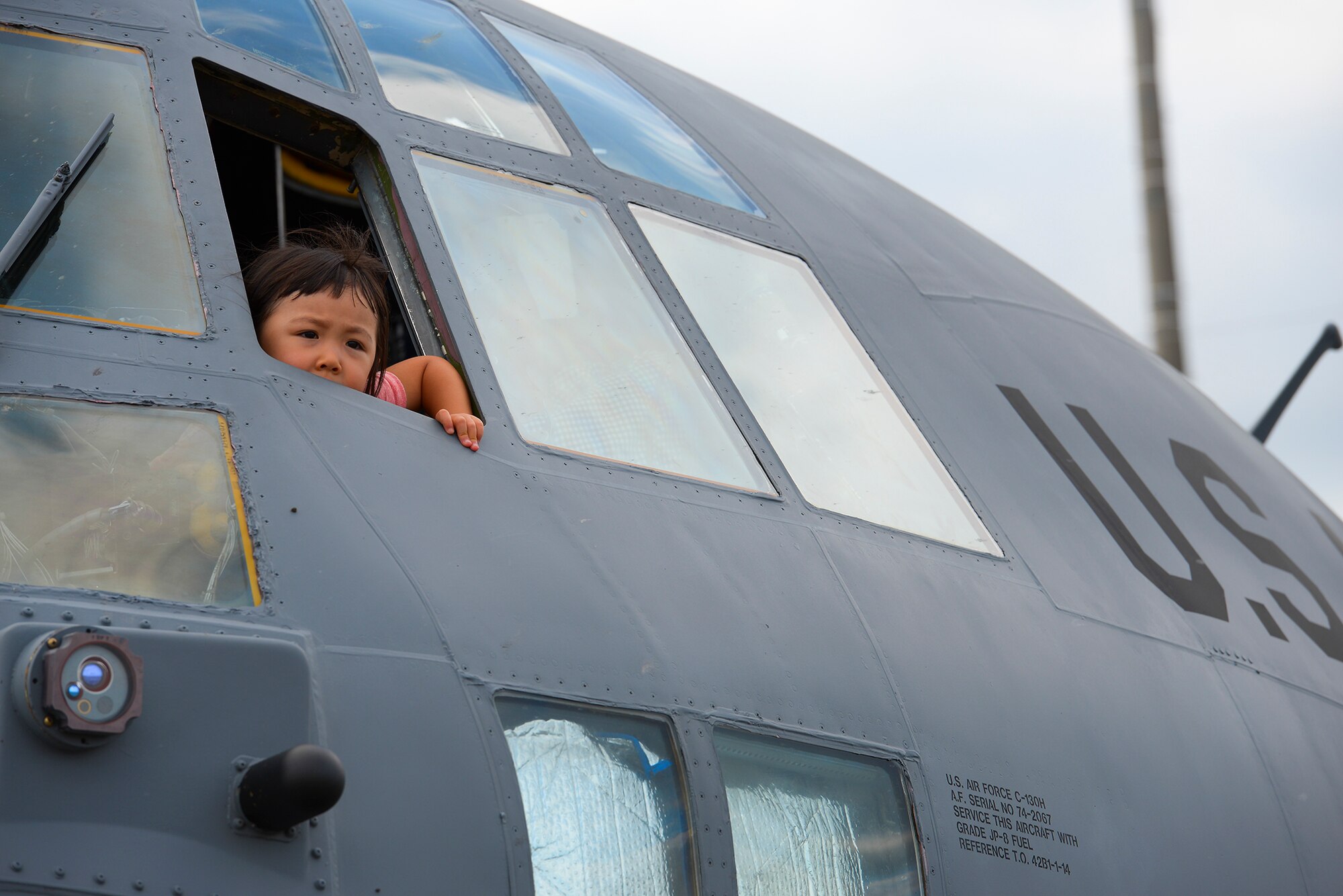 A child looks out the window of a C-130 Hercules during the Japanese-American friendship festival at Yokota Air Base, Japan, Sept. 20, 2015. Yokota invited visitors to explore the inside of some of the aircraft on display at the festival. (U.S. Air Force photo by Airman 1st Class Elizabeth Baker/Released)