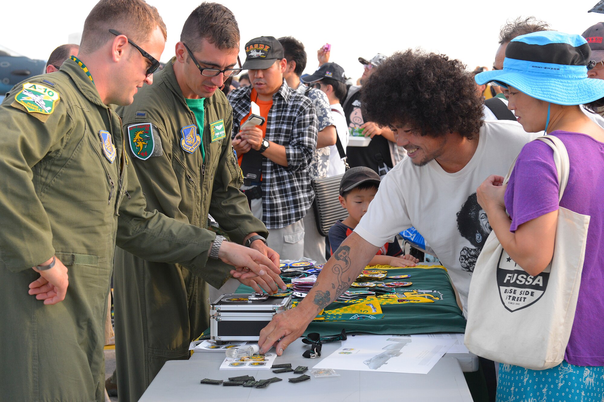 Visitors browse merchandise related to a static aircraft display during the Japanese-American Friendship festival Yokota Air Base, Japan, Sept. 20, 2015. Many attendees displayed the emblems of the Air Force as well as Yokota squadrons and wings as they explored the grounds. (U.S. Air Force photo by Airman 1st Class Elizabeth Baker/Released)