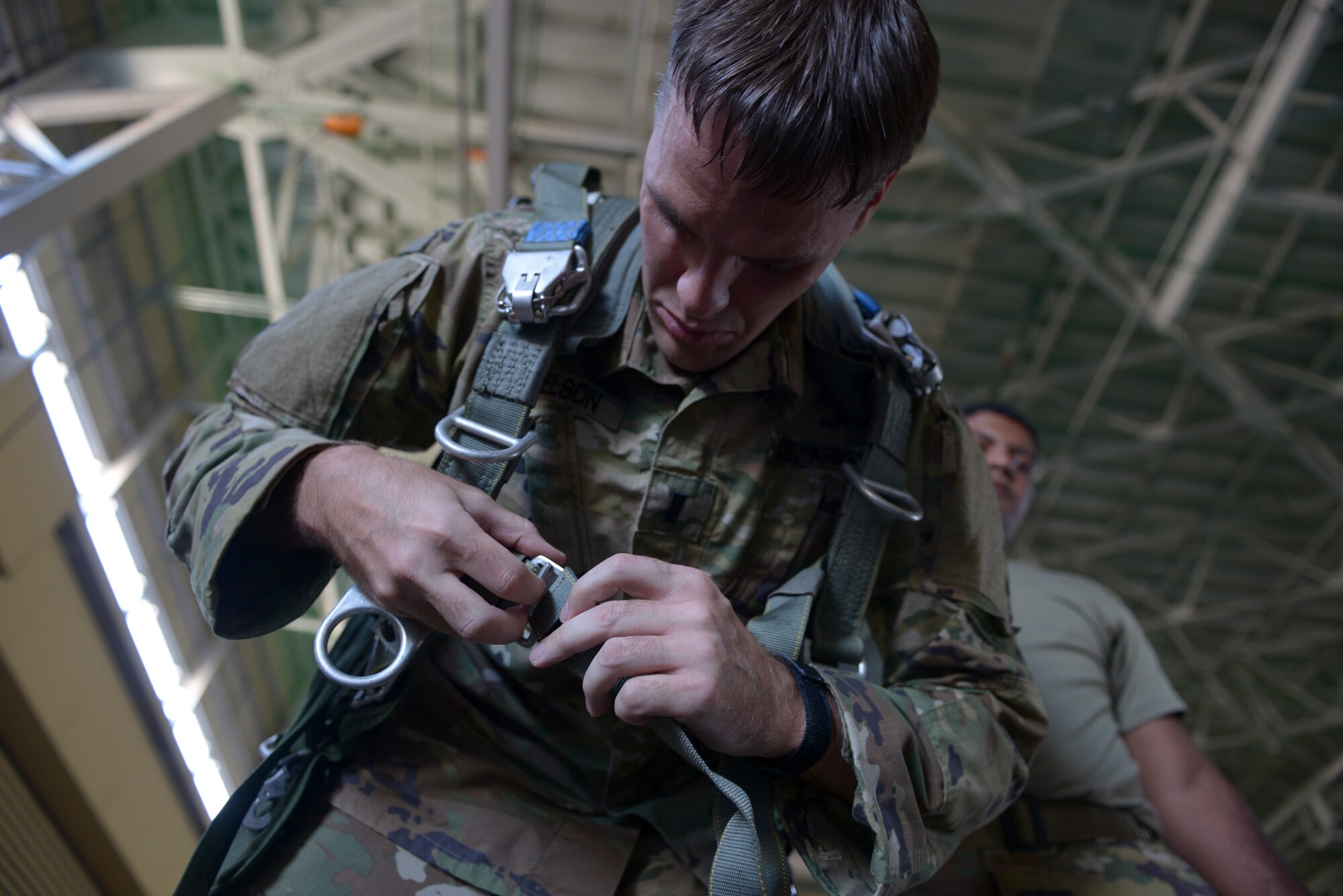 US Army Lt. John Donelson, 1st Battalion, 1st Special Operations Group (Airborne), dons a parachute pack during the 2015 Japanese-American Friendship Festival at Yokota Air Base, Japan, Sept. 20, 2015. More than 40 Soldiers jumped from C-130s during the two-day event, highlighting Yokota's airdrop capability to the crowd; more than 185,000 people attended the festival. (U.S. Air Force photo by Staff Sgt. Cody H. Ramirez/Released)