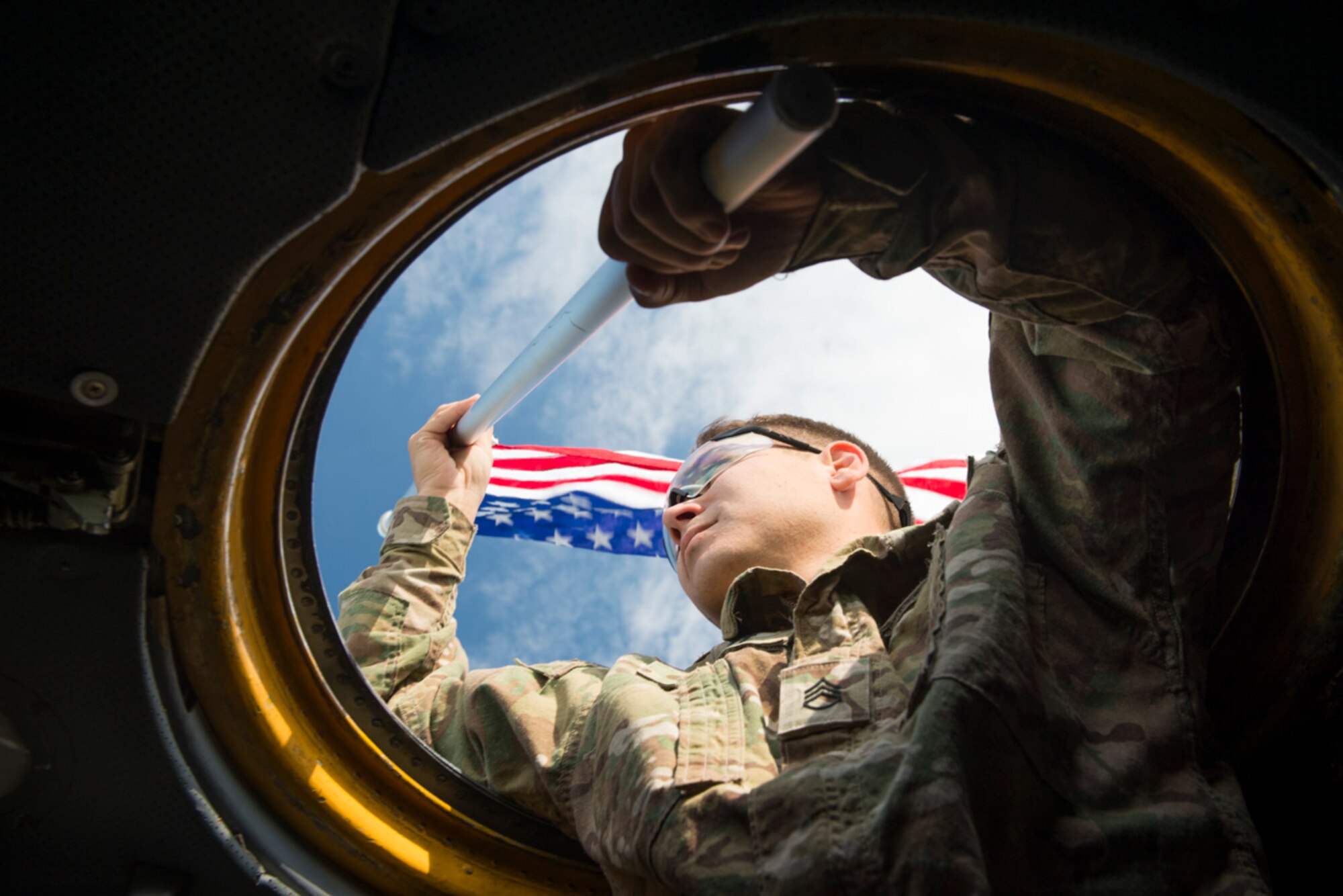 Staff Sgt. Brian Wright, 1st Battalion, 1st Special Operations Group (Airborne), holds a US flag outside a C-130 Hercules during the 2015 Japanese-American Friendship Festival at Yokota Air Base, Japan, Sept. 20, 2015. The US flag, waved by Wright, was held out one C-130 and a Japanese flag was simultaneously held outside another taxing aircraft, symbolizing the US and Japan partnership and reinforcing the general idea of the festival--to increase bilateral relationships between the two countries. (U.S. Air Force photo by Staff Sgt. Cody H. Ramirez/Released)