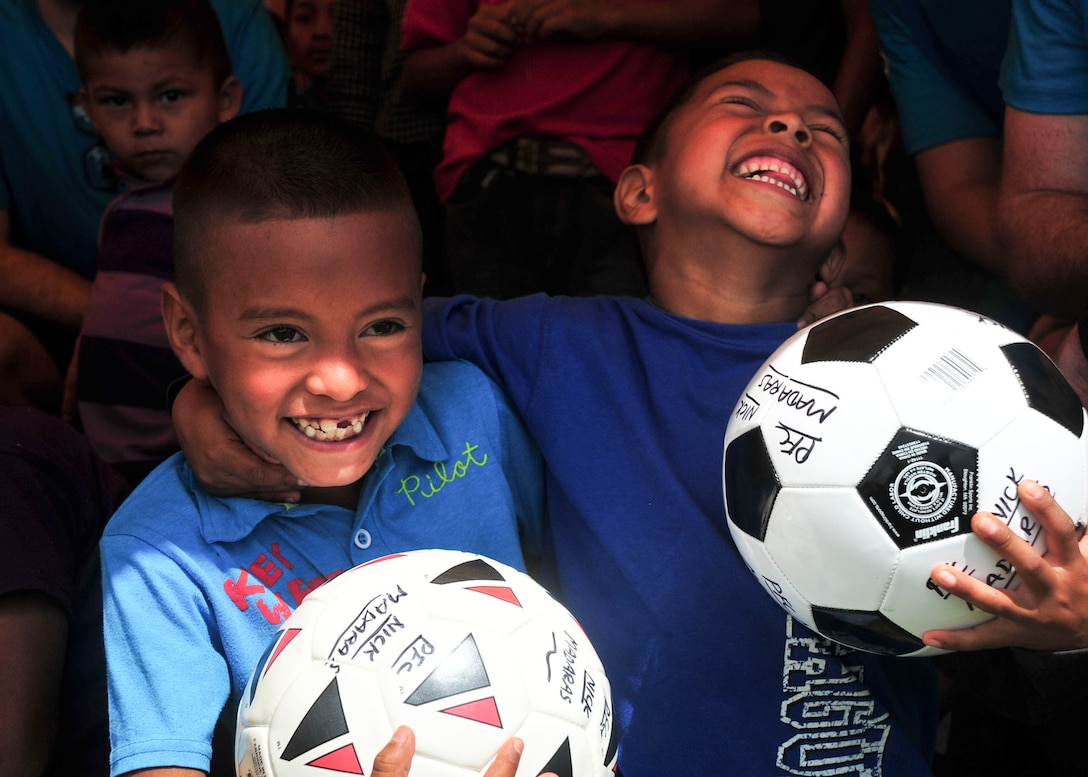 SOTO CANO AIR BASE, Honduras – Two school-age boys laugh as they hold new soccer balls during the 63rd Joint Task Force-Bravo Chapel Hike in Calavera Centro, Honduras, Sept. 19, 2015. Volunteers from JTF-Bravo distributed these soccer balls, and a number of others, to schools in this remote, mountain village as part of a larger humanitarian assistance and partnership-building event. (U.S. Air Force photo by Capt. Christopher Love)