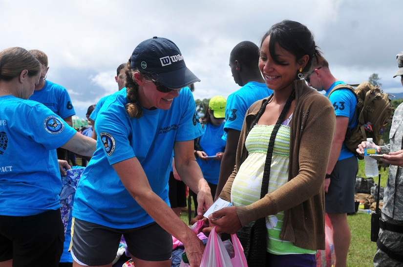 SOTO CANO AIR BASE, Honduras – U.S Army Capt. Penny Wood, Joint Task Force-Bravo Emergency Medical Team officer in charge, helps Linda Flores find clothes for unborn child during the 63rd Joint Task Force-Bravo Chapel Hike Sept. 19, 2015, in Calavera Centro, Honduras. The Chapel Hike program is a bi-monthly humanitarian assistance, volunteer event; at 11,500 pounds of goods, this was the largest Chapel Hike on record, with donations coming from throughout the United States and even England. (U.S. Air Force photo by Capt. Christopher Love)