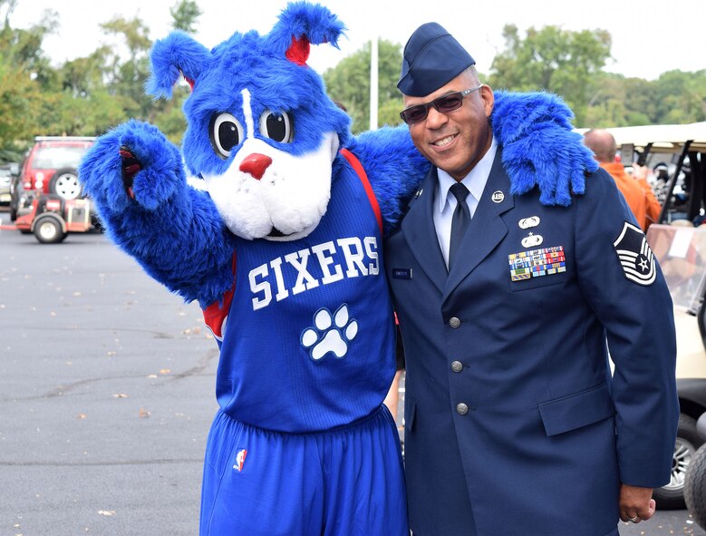 HORSHAM AIR GUARD STATION, Pa., -- Master Sgt. Sterling Randolph, wireless systems technician with the 111th Communications Flight, pals up with the Philadelphia Seventy Sixers new mascot, Franklin, during the 7th Annual Liberty USO Celebrity Golf Outing, Concord Country Club, Concord, Pa., Sep. 22, 2015, before belting out the National Anthem to kick the event off. Nearly 200 golfers participated as well as area sports celebrities such as Darren Daulton, Mickey Morandini and Seth Joyner. (U.S. Air National Guard photo by Master Sgt. Christopher Botzum/Released)