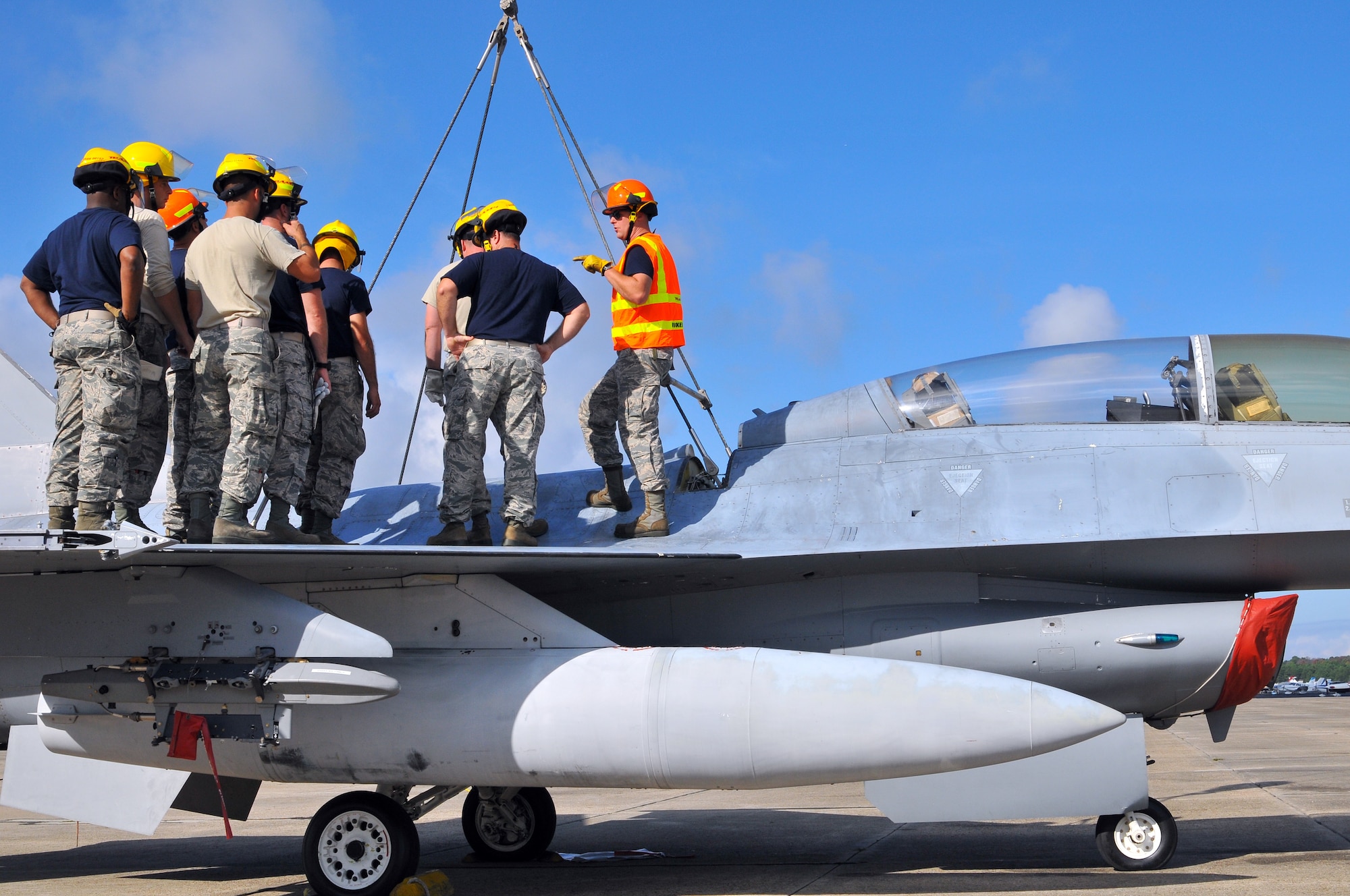 A picture of U.S. Air Force Master Sgt. Christopher Foye from the New Jersey Air National Guard 177th Fighter Wing Crash Disabled Damaged Aircraft Recovery team briefing the rest of his team on top of an F-16 Fighting Falcon.