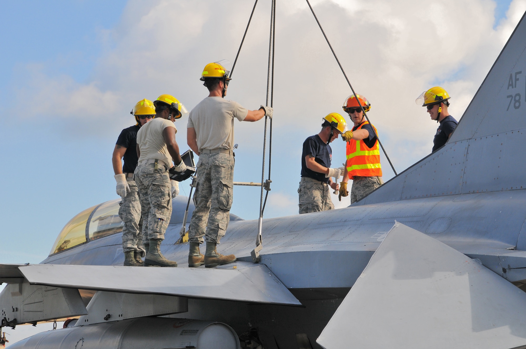 A picture of U.S. Air Force Master Sgt. Christopher Foye, from the New Jersey Air National Guard 177th Fighter Wing Crash Disabled Damaged Aircraft Recovery team, briefing the rest of his team on top of an F-16 Fighting Falcon.